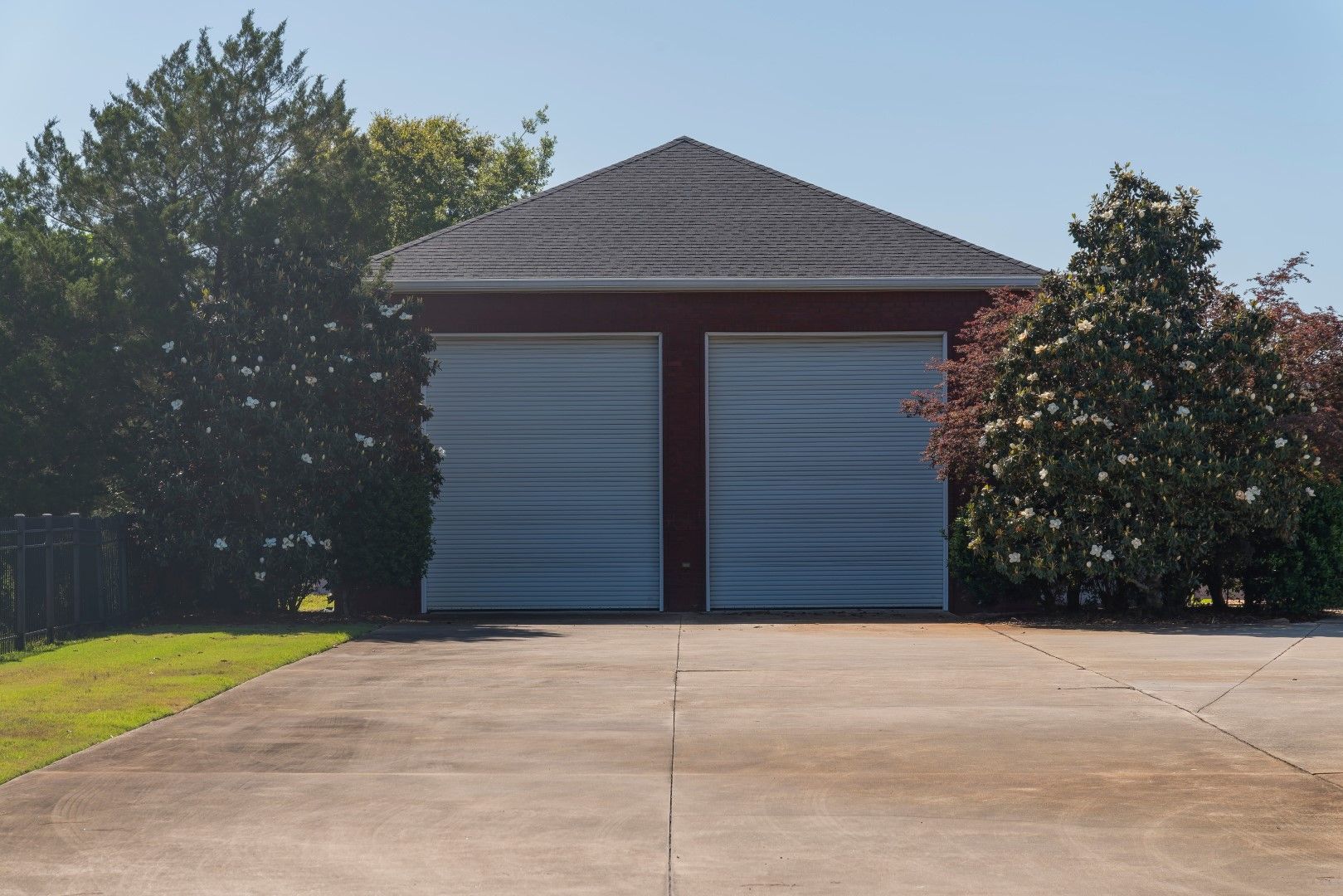A garage with two garage doors and a driveway leading to it