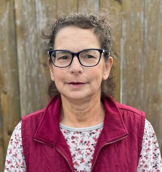 A woman wearing glasses and a champion kennels sweatshirt.