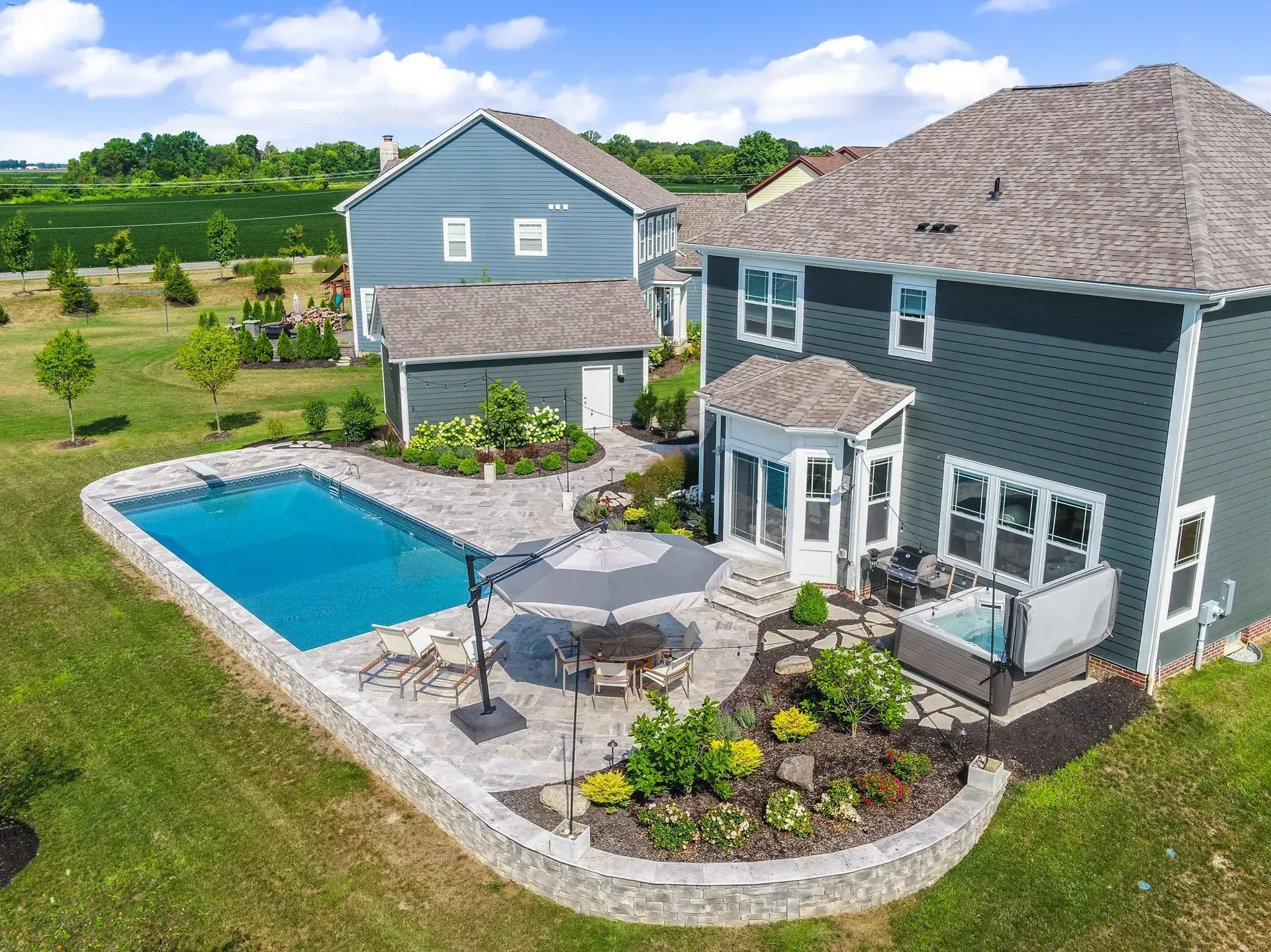 An aerial view of a large house with a large swimming pool.