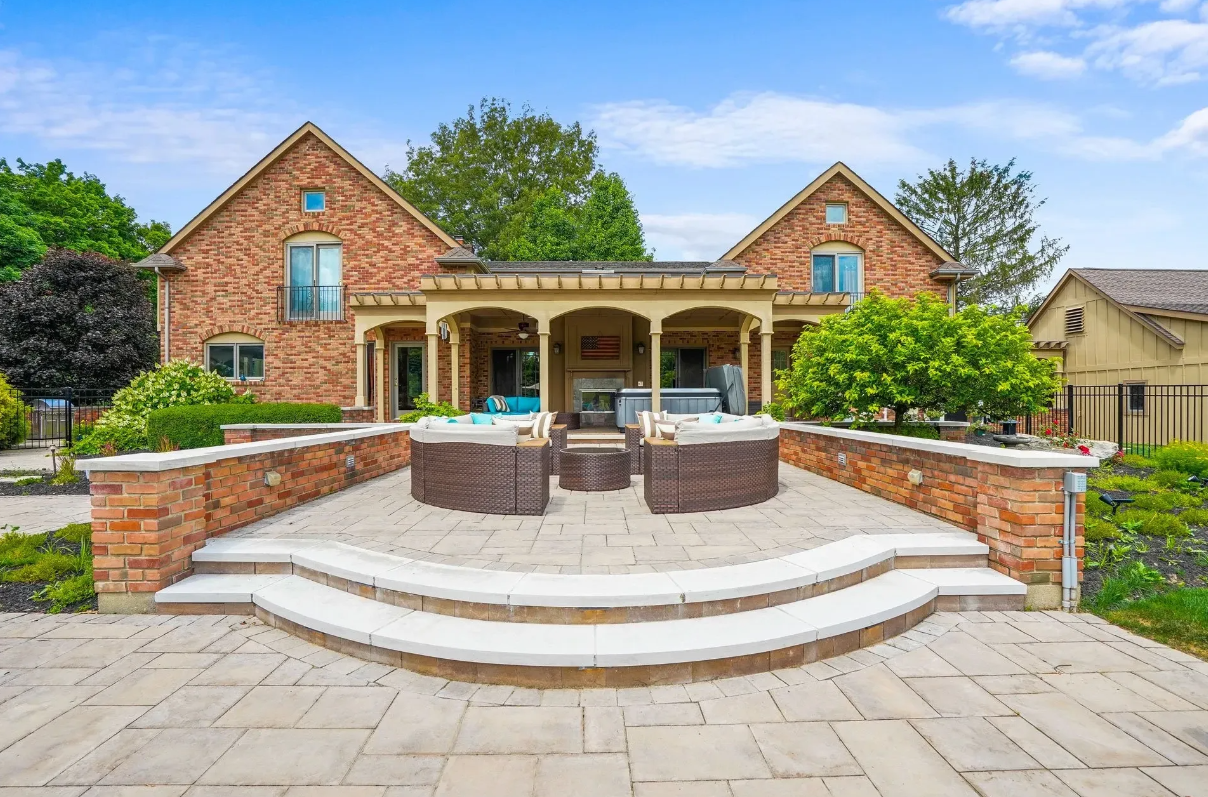 Brick patio with outdoor furniture and brick wall.