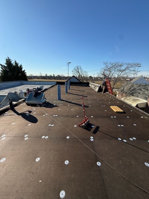 Rooftop with fallen HVAC units and scattered debris under a clear blue sky