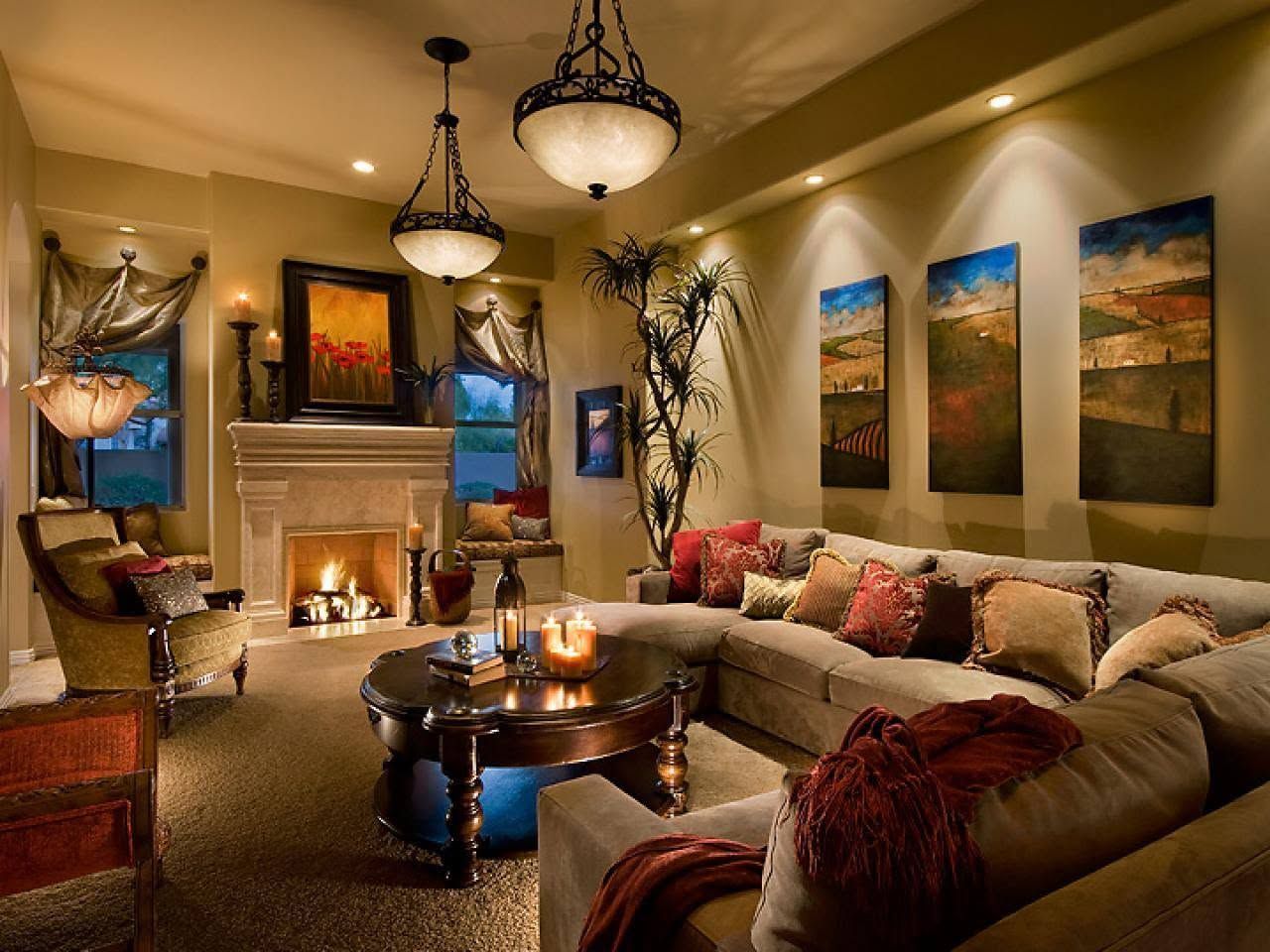 Elegant living room with beige sectional, fireplace, chandelier lights, and colorful wall art
