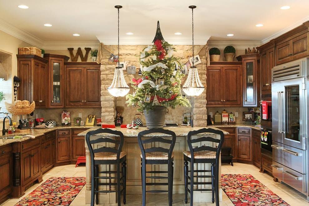Festive kitchen with a decorated Christmas tree, island stools, and warm wood cabinets