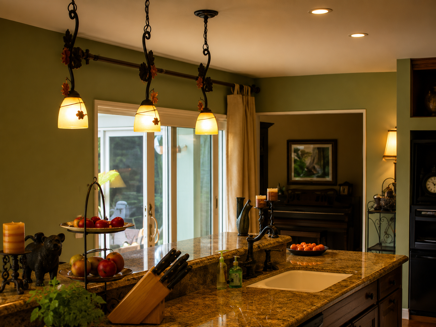 Modern kitchen with granite island, hanging pendant lights, and view of a fireplace in the background