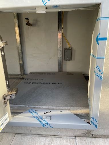 Unfinished wall opening with exposed framing and insulation board in a construction area.