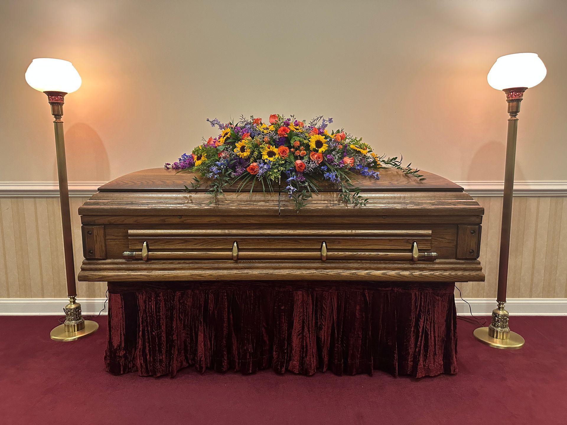 A traditional funeral service with a casket spray of flowers.