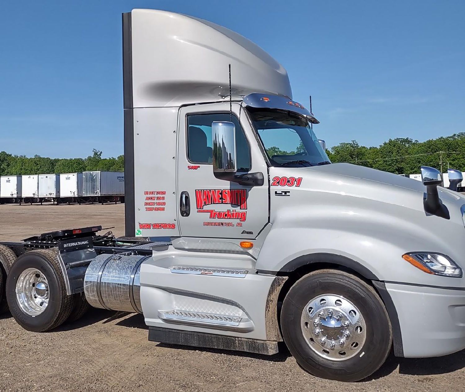 Silver semi-truck cab parked outdoors on a sunny day