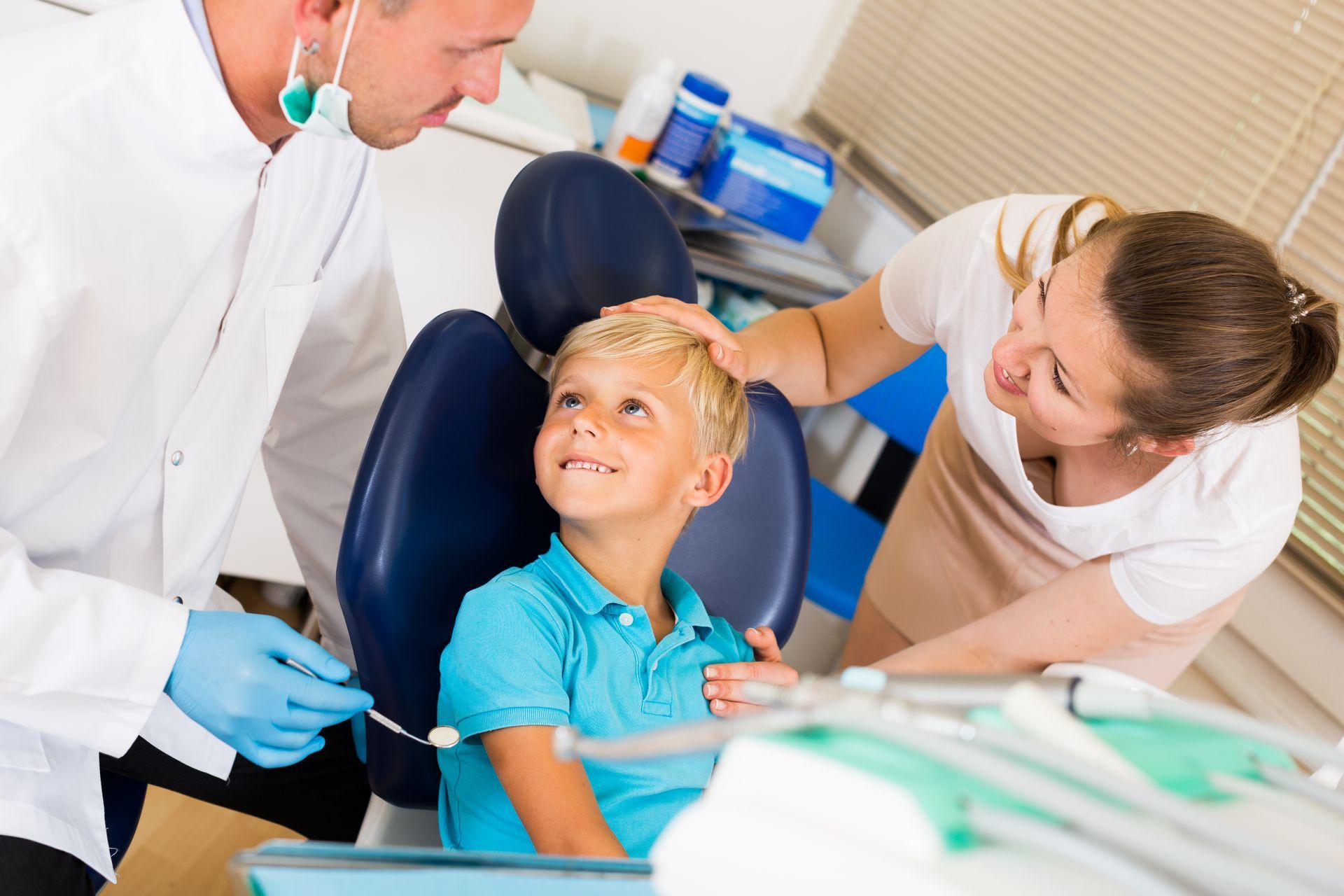 A child with mother is visiting a dentist in a dental office.