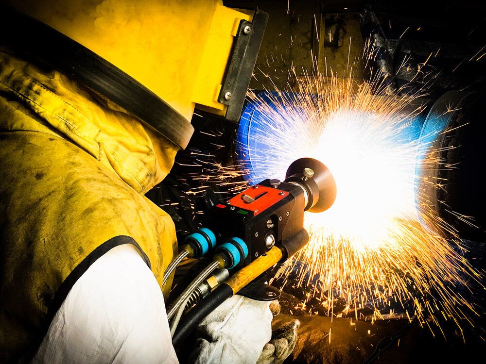 A person is metal spraying  — Curtin Engine Reconditioning Pty Ltd In Paget, QLD