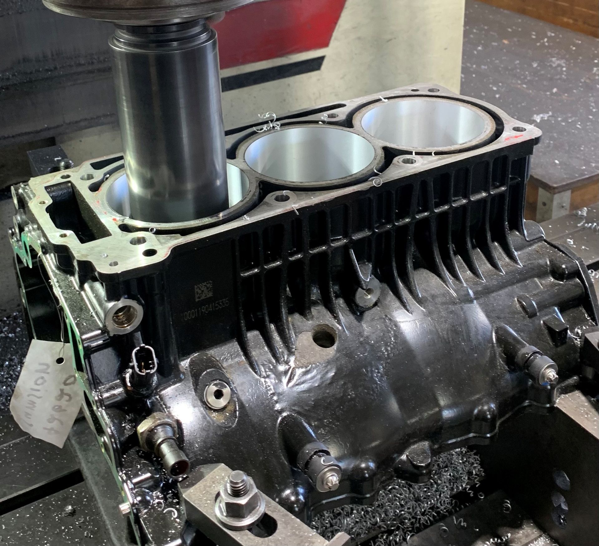 A black engine block is being machined by a milling machine — Curtin Engine Reconditioning Pty Ltd In Paget, QLD