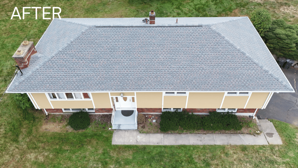 Aerial view of a house with a newly installed gray roof; tan siding, white trim, and a small porch.