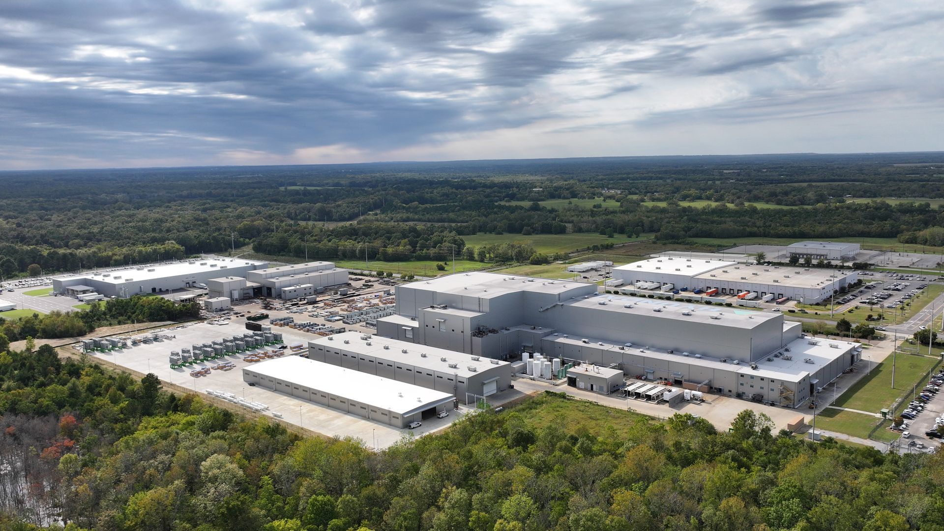 An aerial view of a large industrial area surrounded by trees.