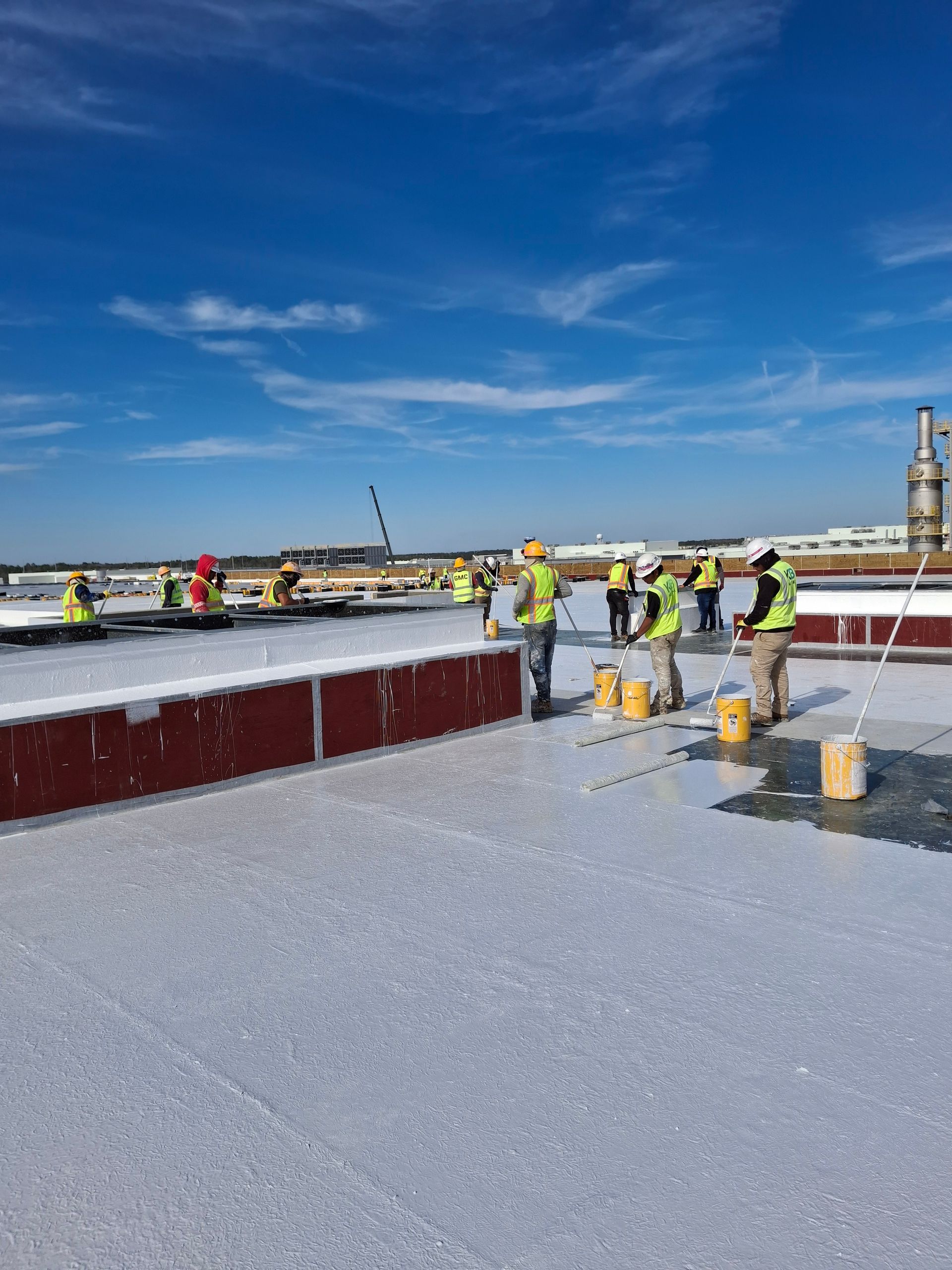A group of construction workers are working on a roof.