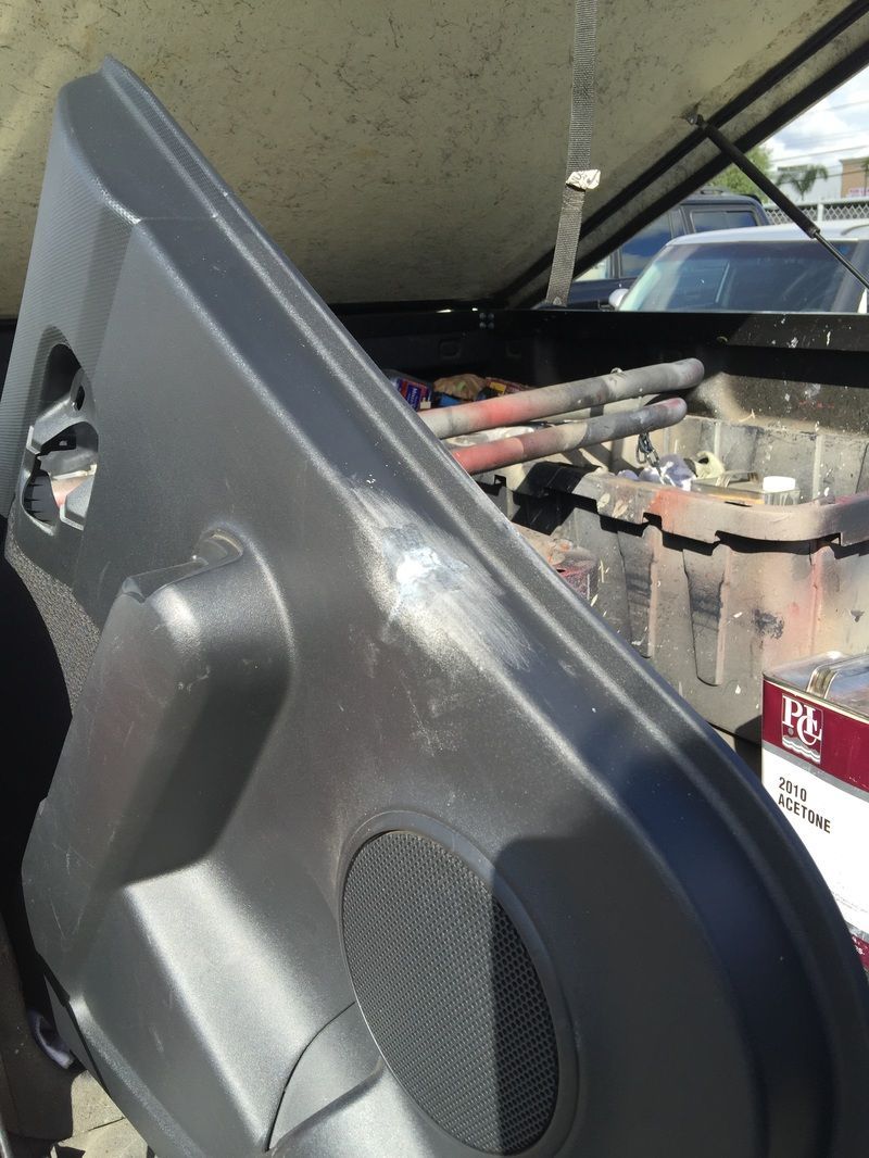 Open car door showing interior wiring and components in a gray vehicle