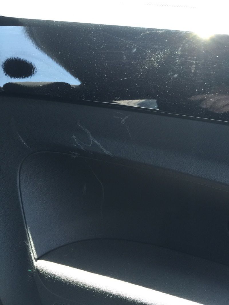 Close-up of a dark car interior panel with sunlight glare on the window