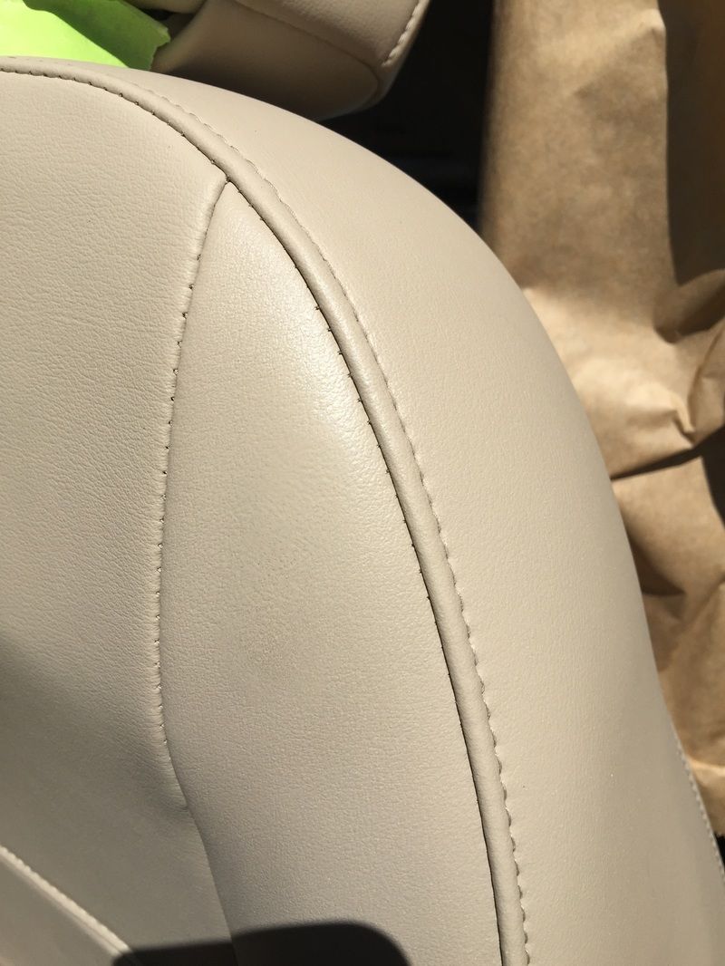 Close-up of a beige leather car seat with stitching detail