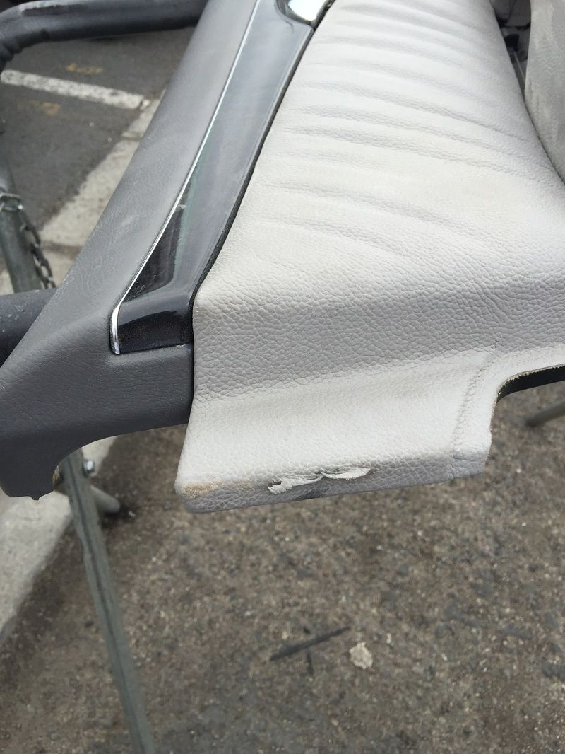 White chair cushion with a torn seam on a gray folding chair outdoors