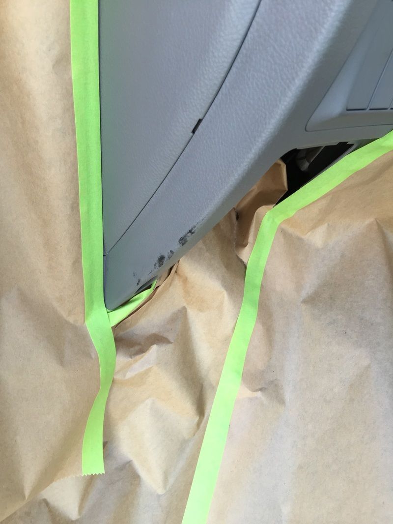 Car seat masked with brown paper and green painter’s tape during repair or painting
