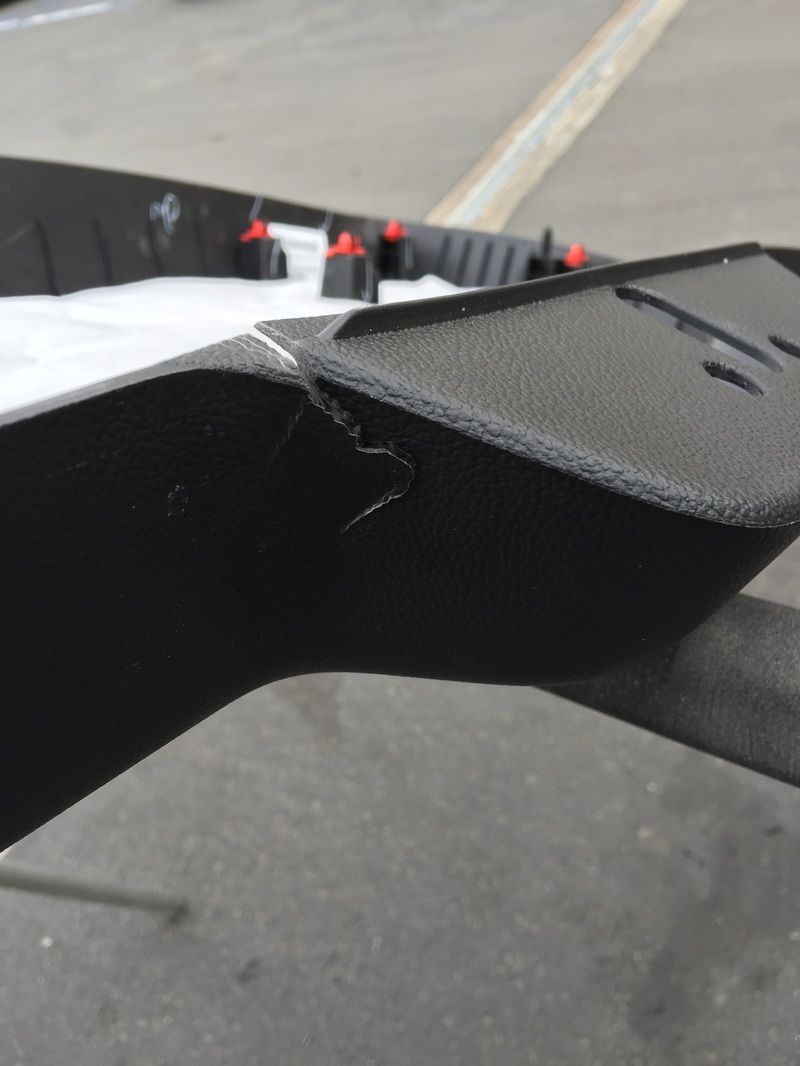 Close-up of a black foam or rubber object with a torn edge on a pavement surface.