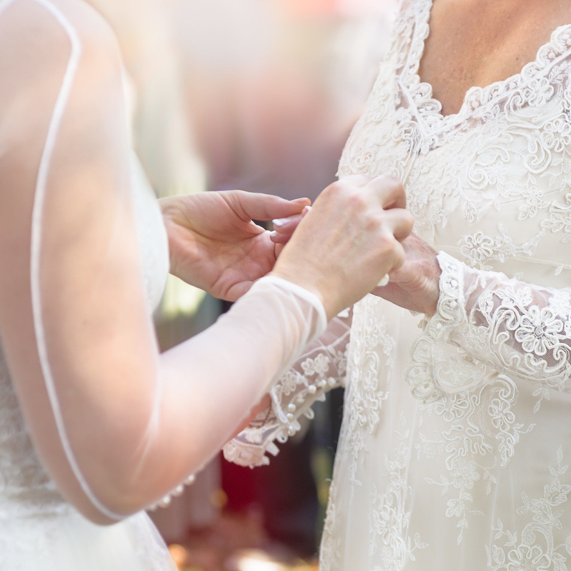 A bride is putting a wedding ring on another bride 's finger.