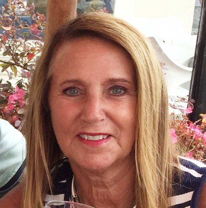 A close up of a woman 's face with flowers in the background