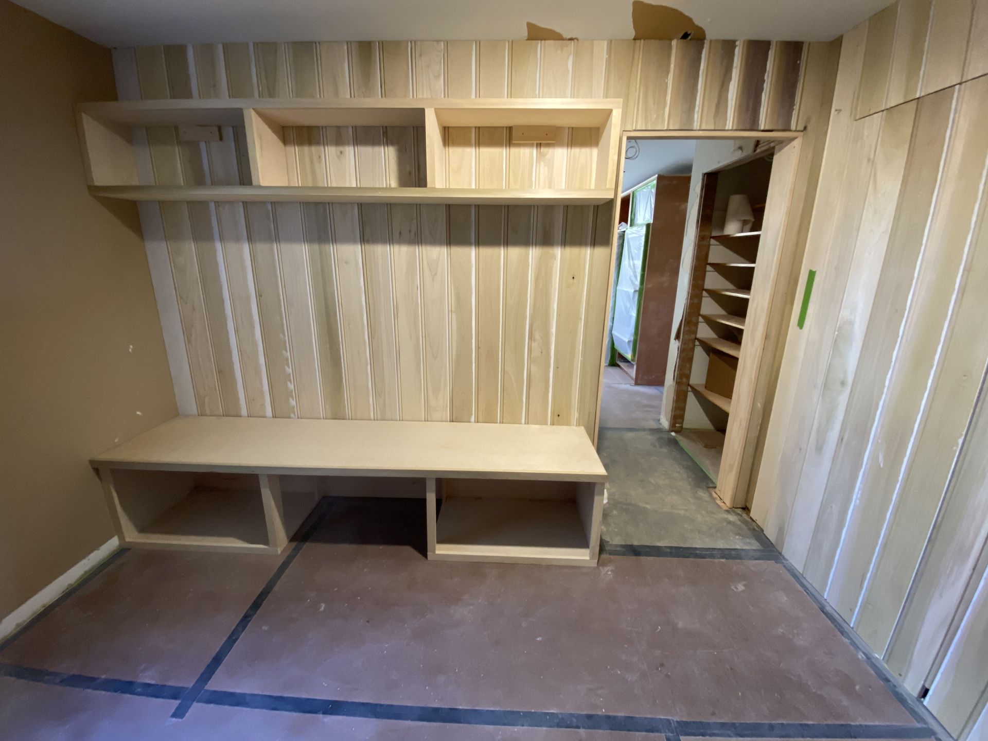 An empty room with a wooden bench and shelves