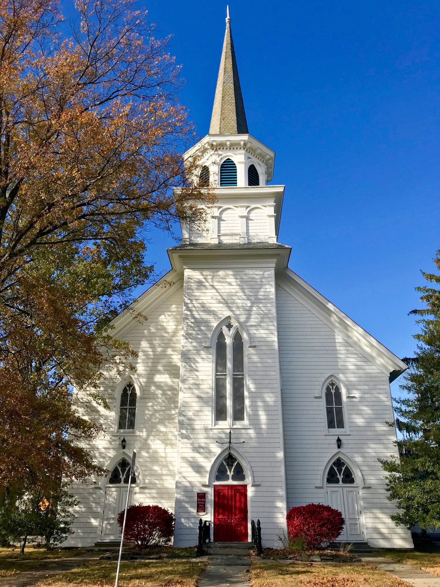 A white church with a red door and a steeple