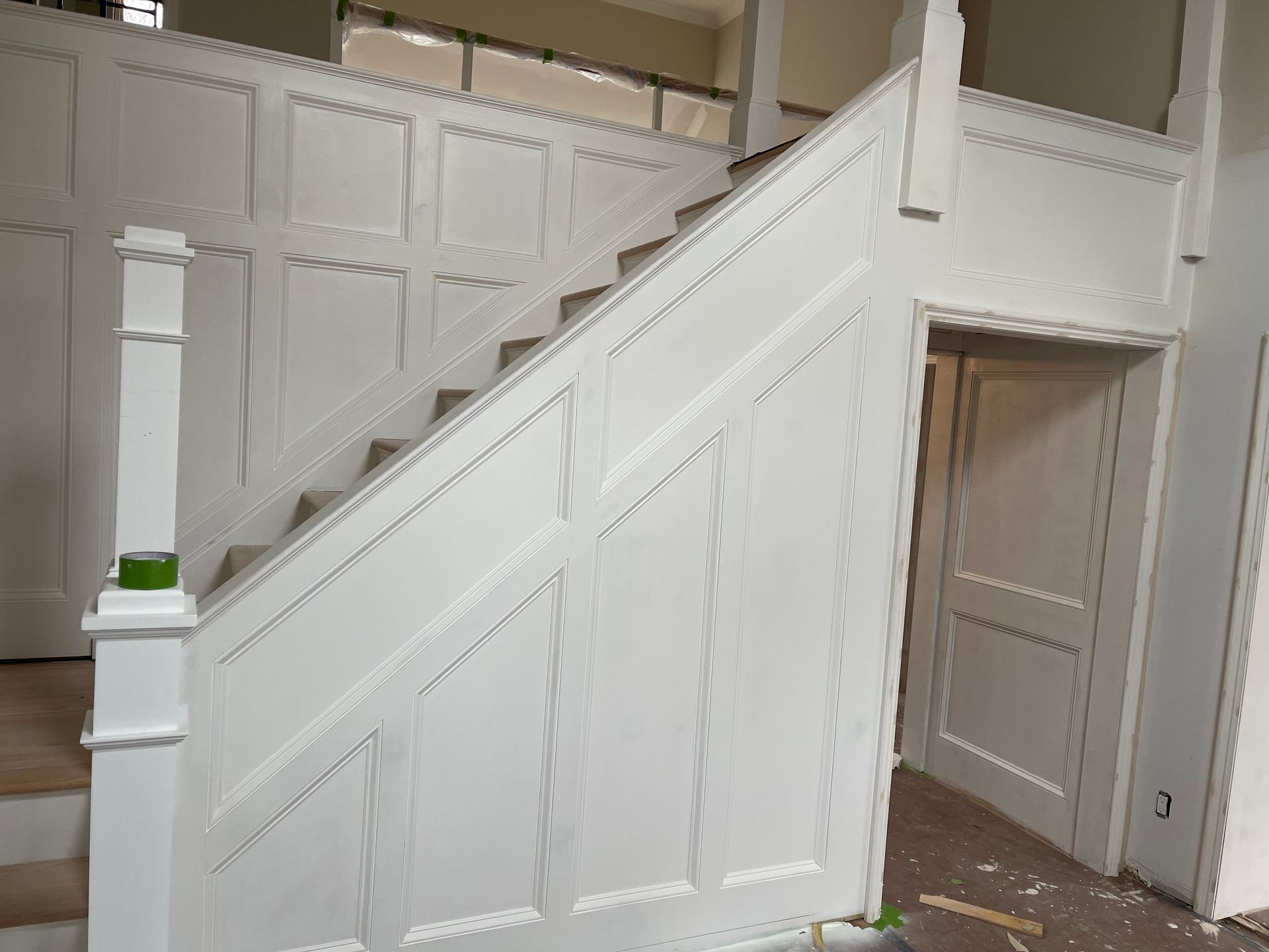 A white staircase in a house under construction.