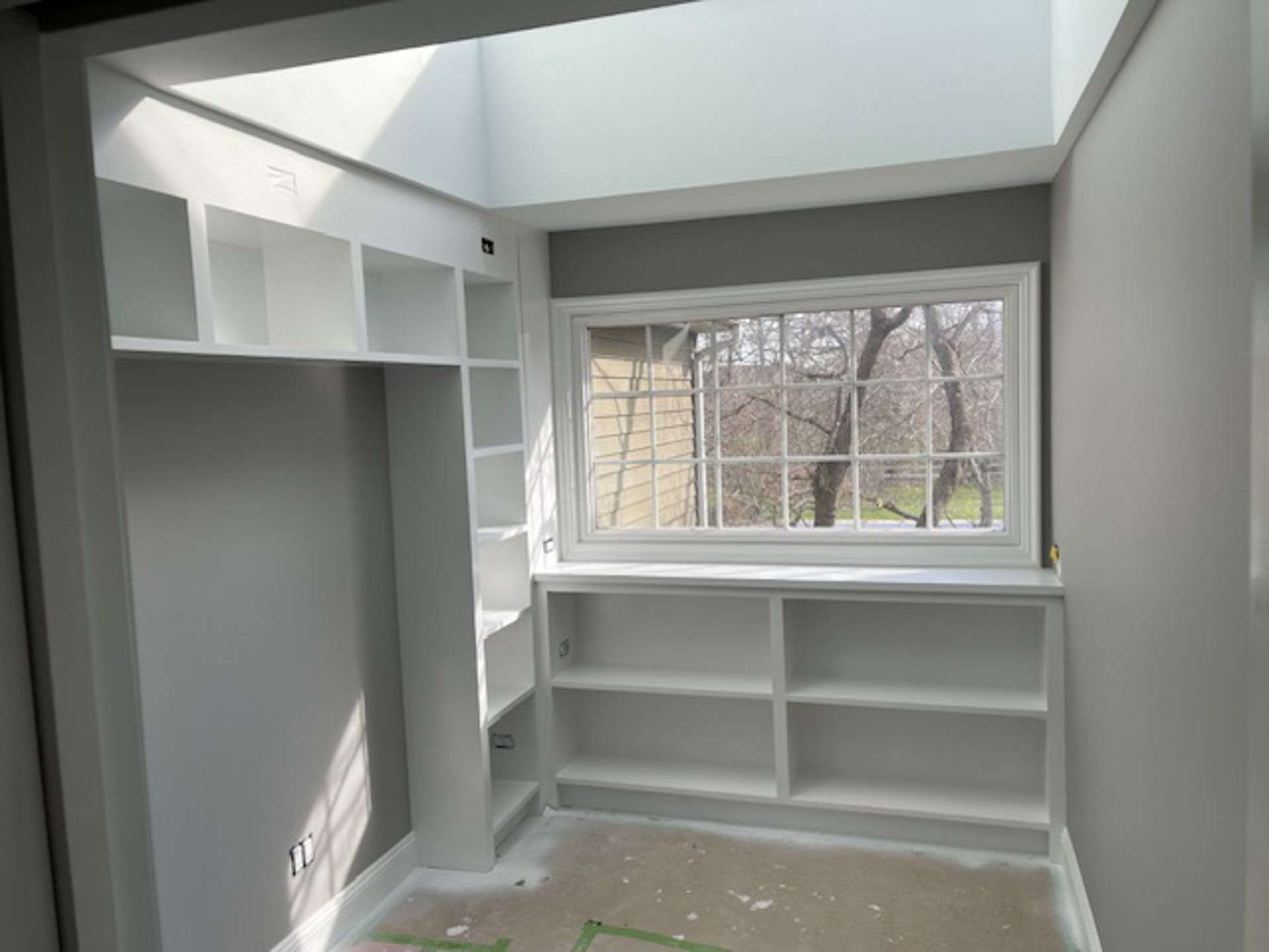 An empty room with shelves and a window