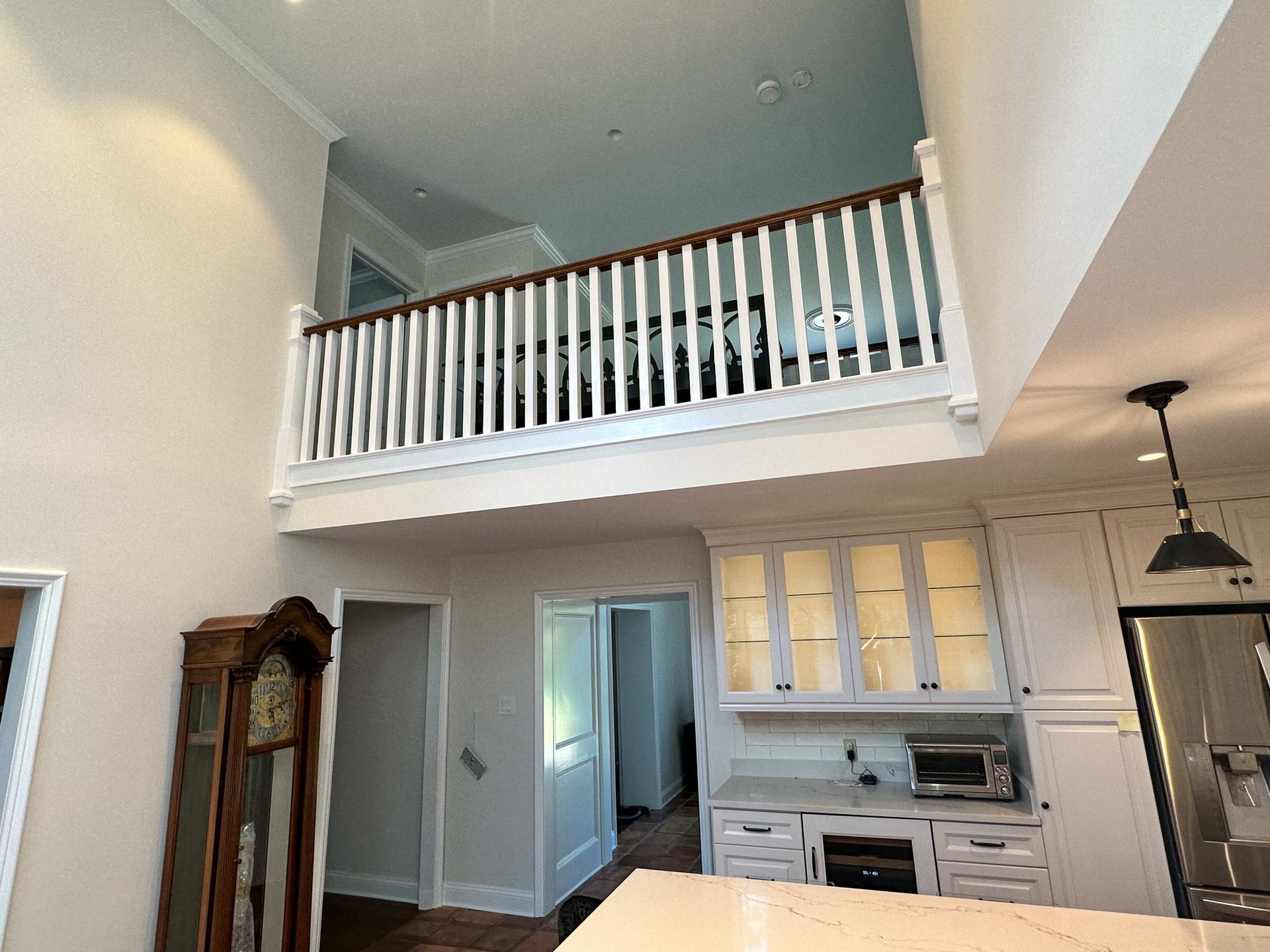 A kitchen with a balcony and a grandfather clock