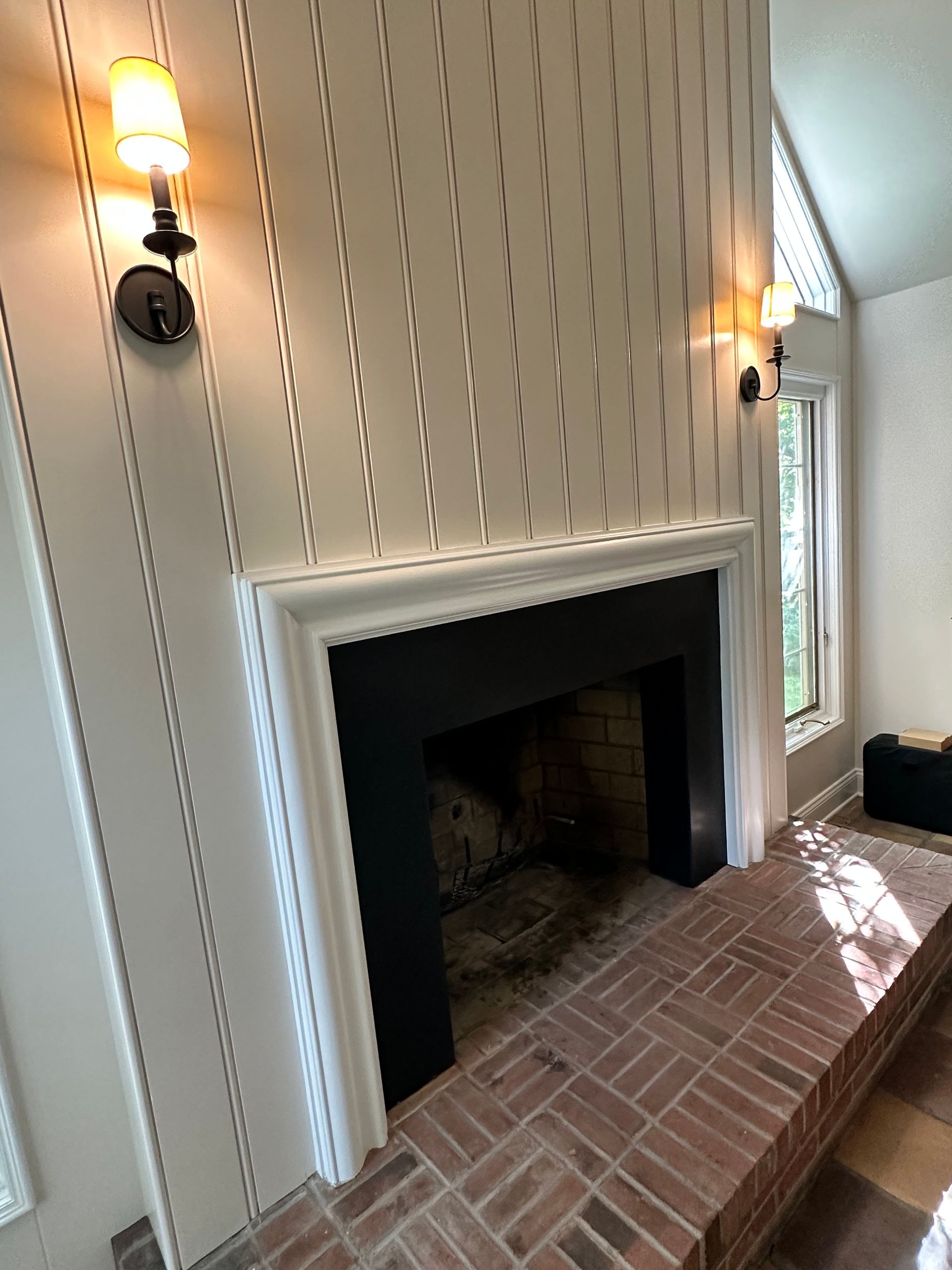 A living room with a fireplace and striped wallpaper