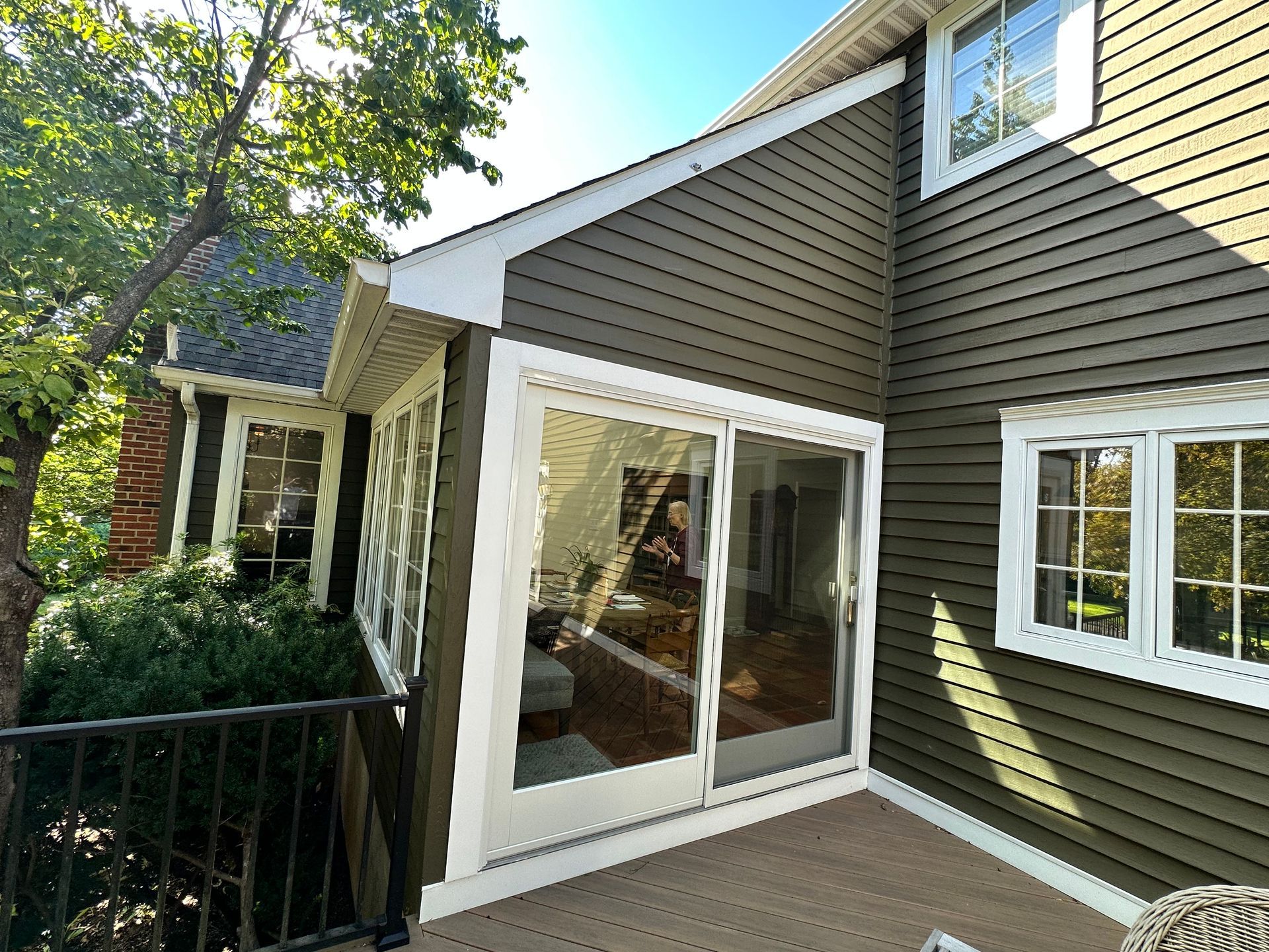 A house with a screened in porch and sliding glass doors.