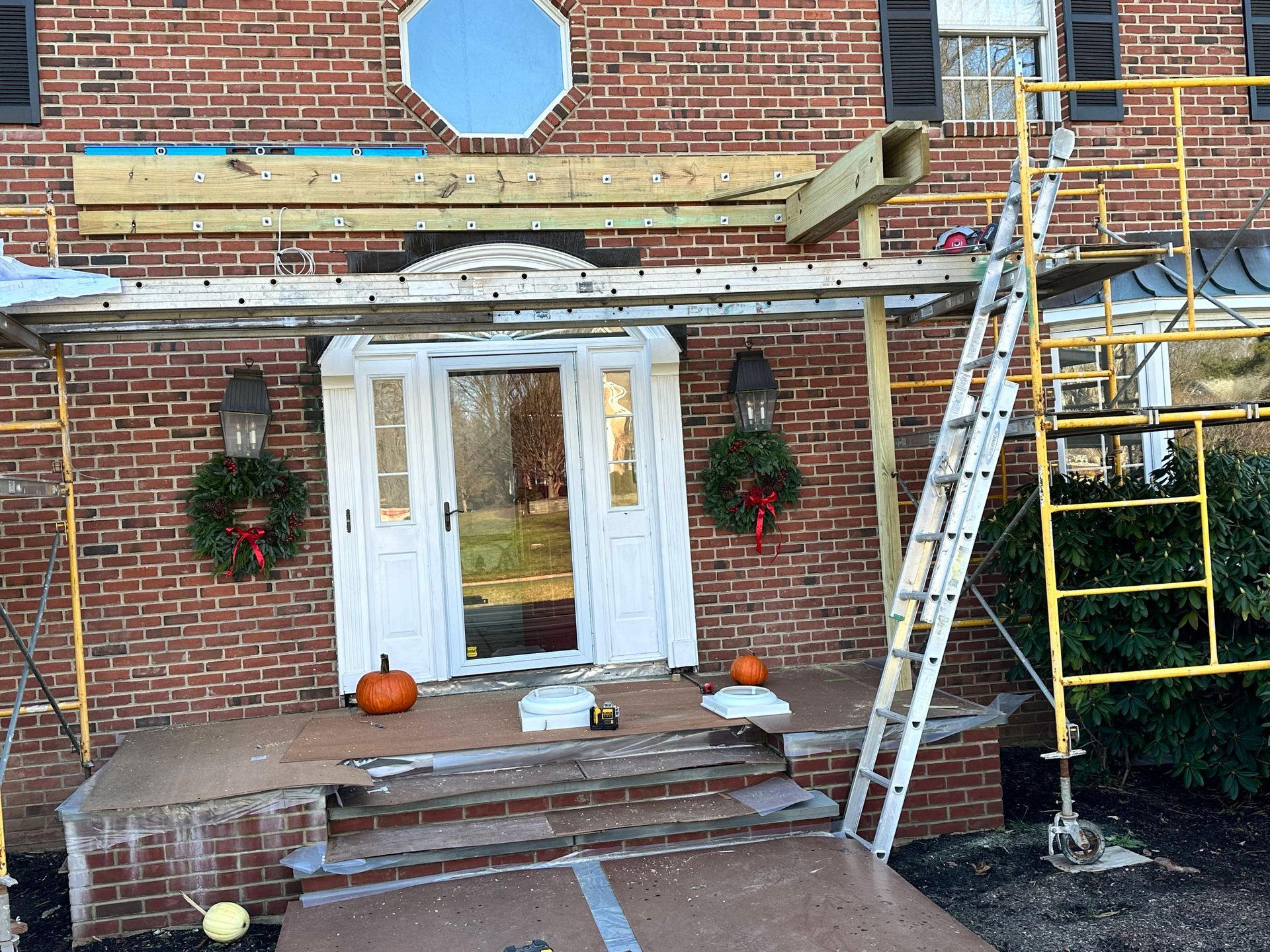 A brick house with a wooden porch being built on top of it.