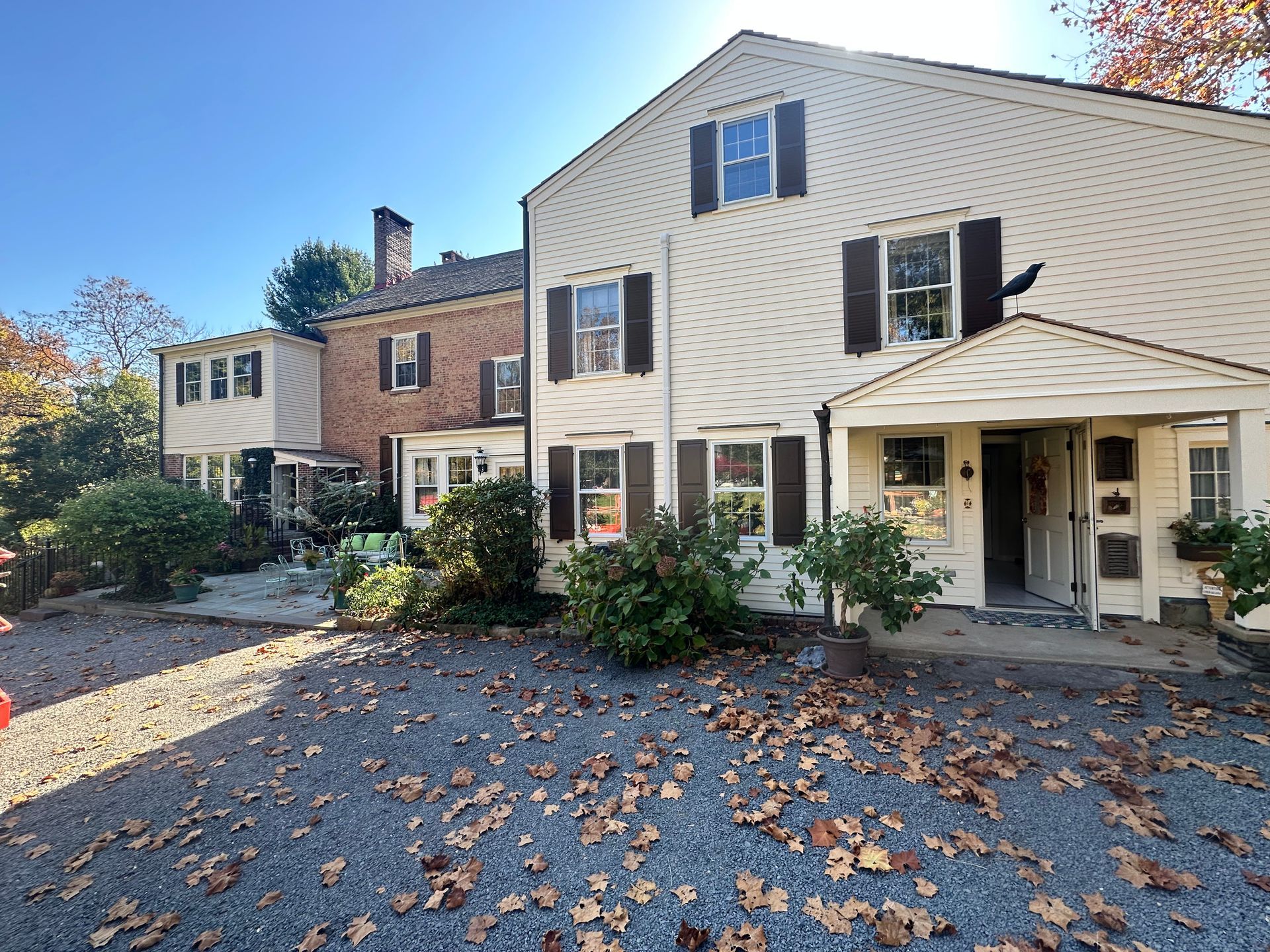 A house with a lot of leaves on the ground in front of it