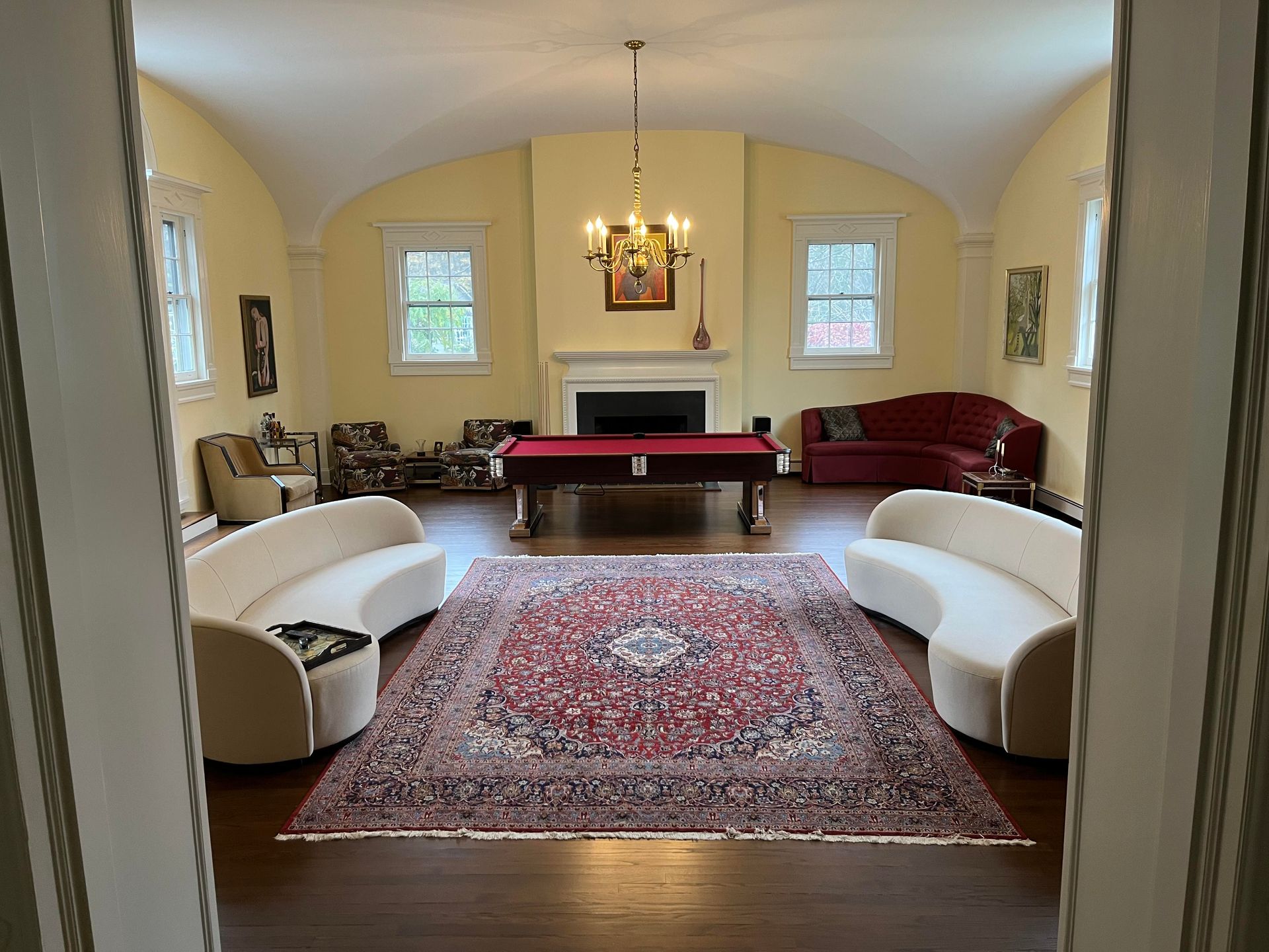 A living room with a pool table and a fireplace