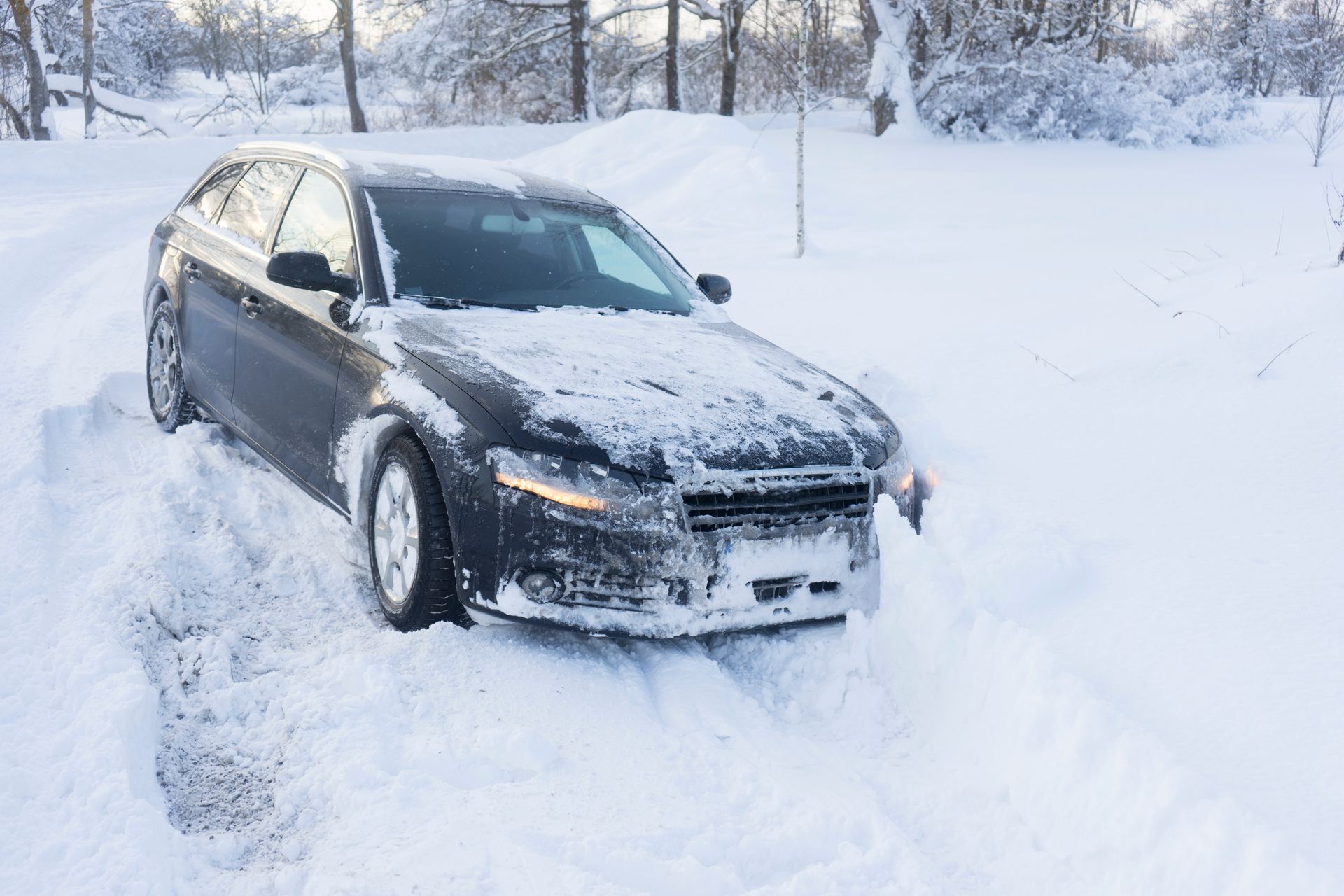 Dark car stuck in deep snow on a snow-covered road. Dark car stuck in deep snow on a snow-covered road.
