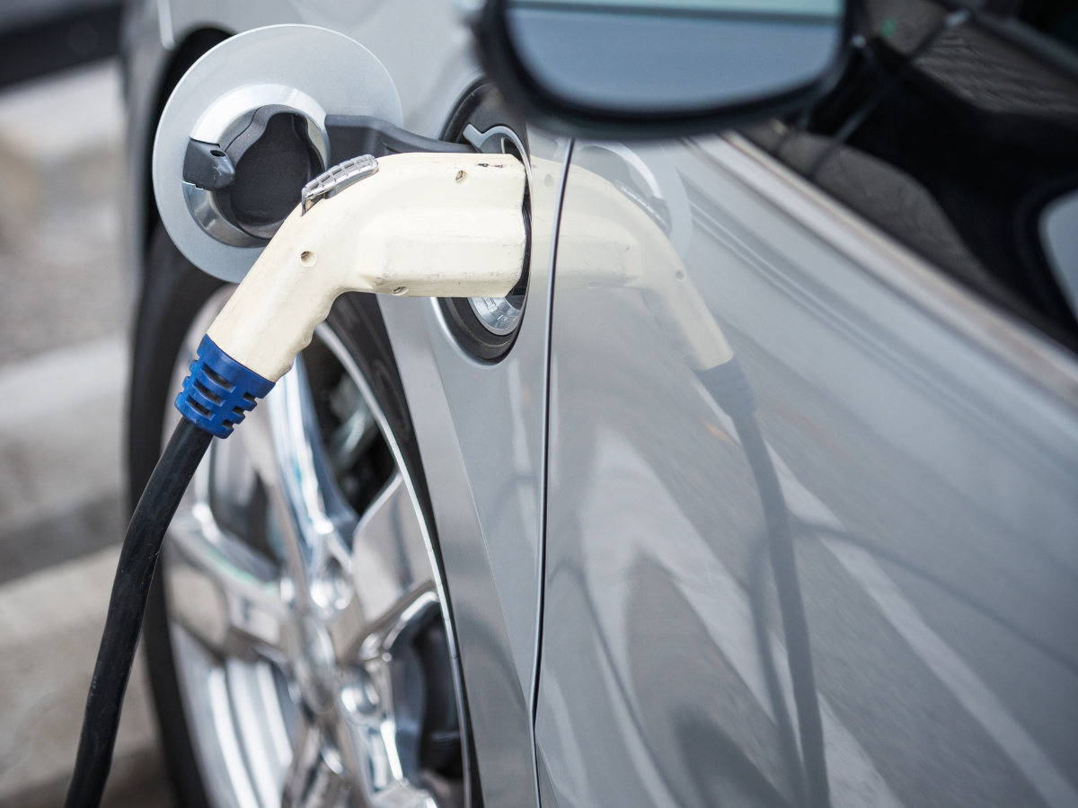 An electric car is being charged at a charging station. An electric car is being charged at a charging station.
