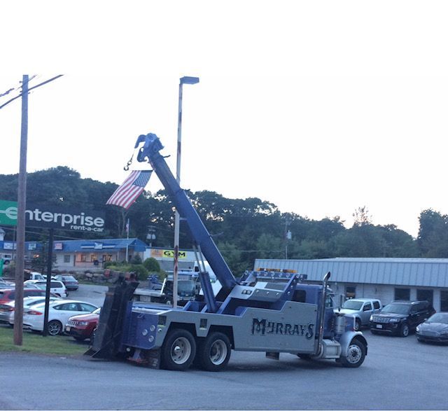 tow truck holding up American flag