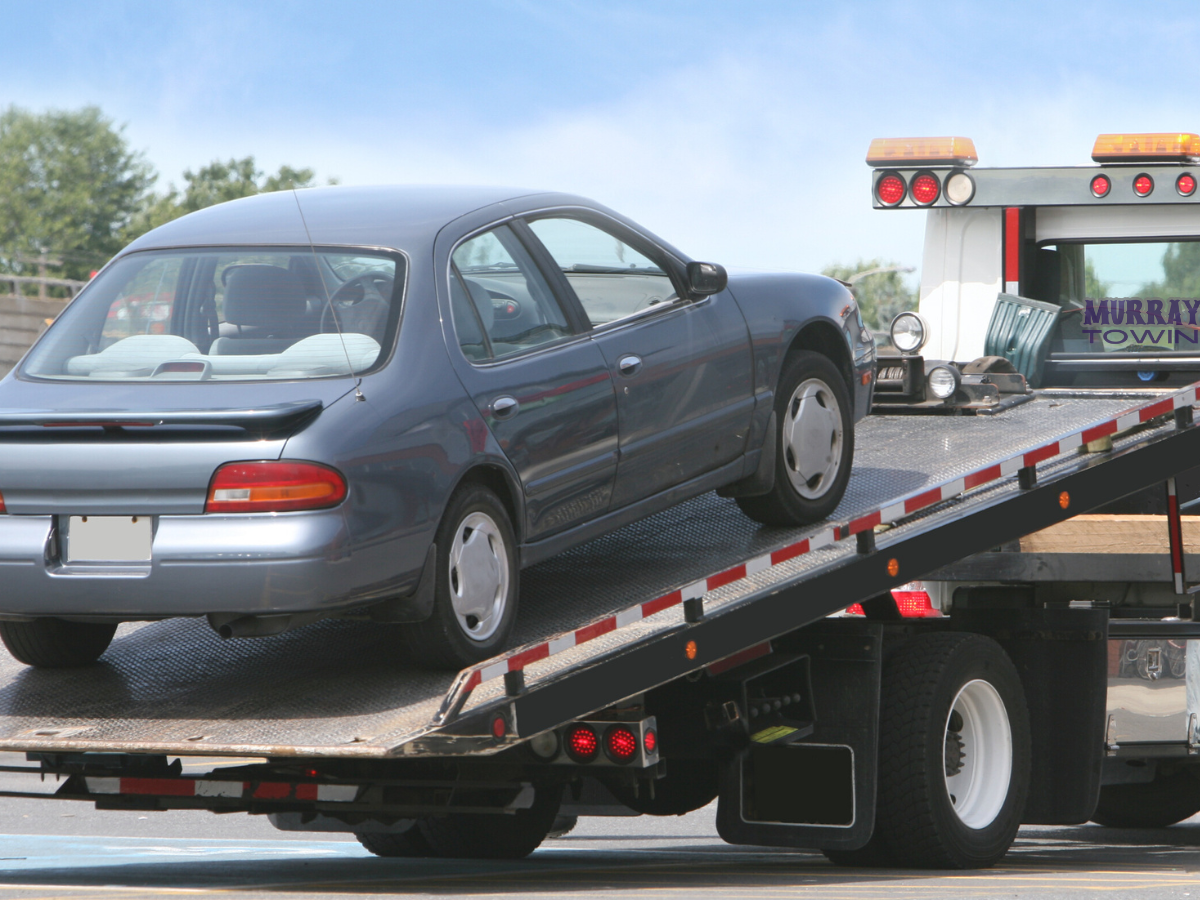 A car is being towed by a murray tow truck A car is being towed by a murray tow truck
