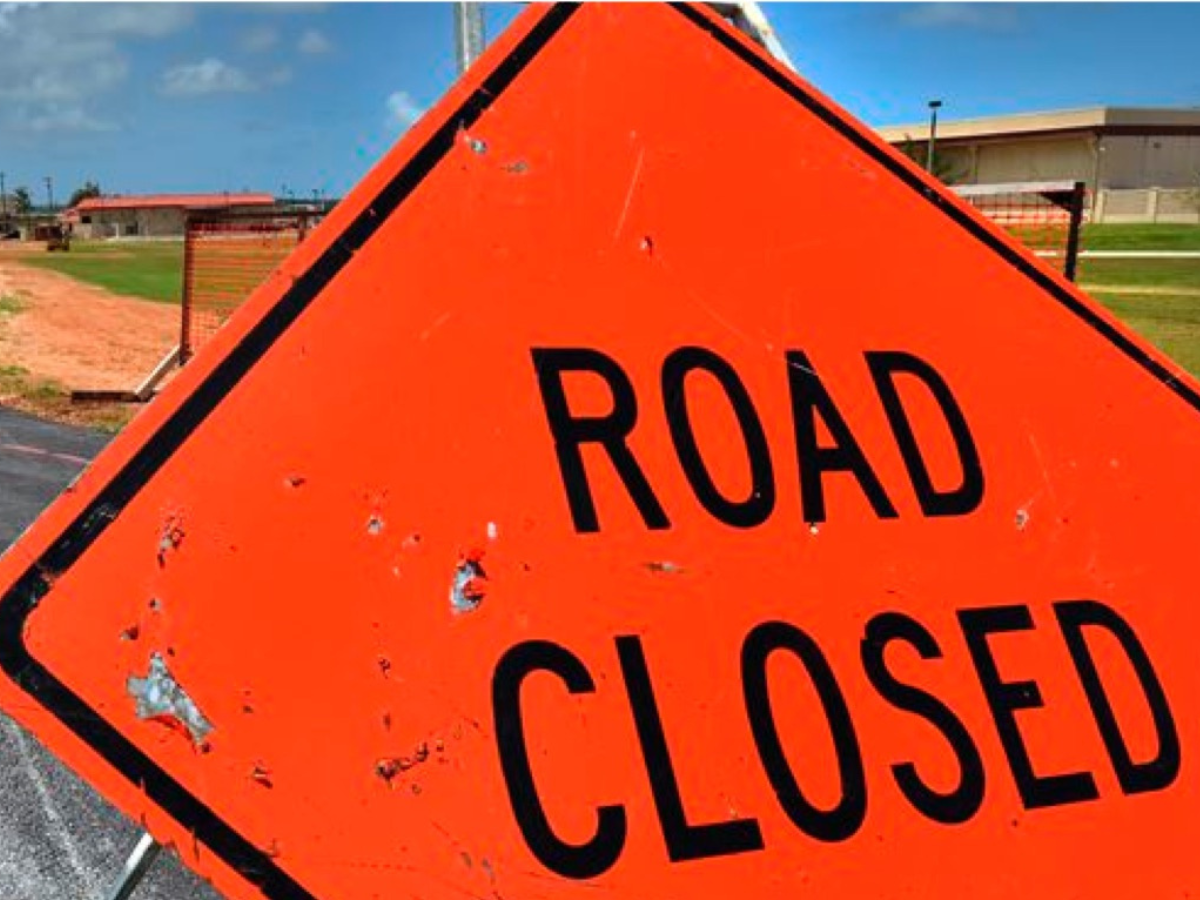 An orange sign that says road closed on it