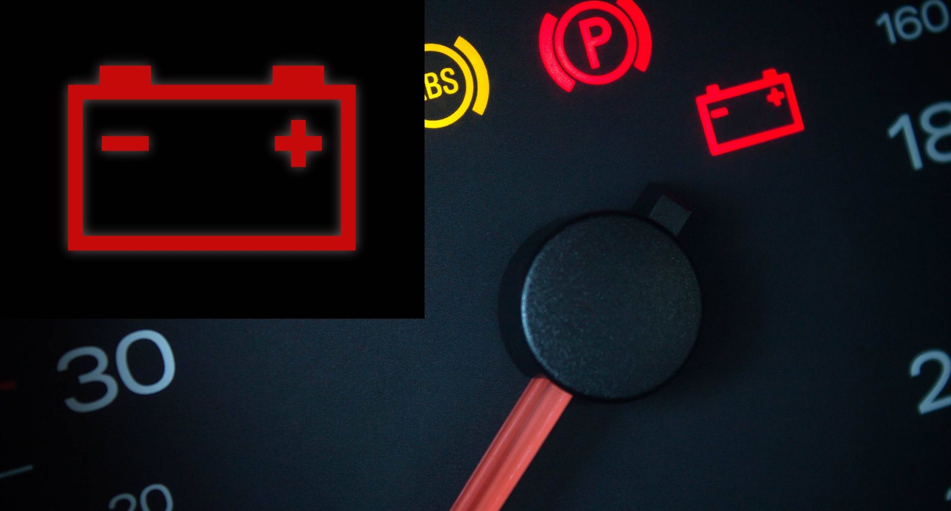 A close up of a car dashboard with a red battery icon and a speedometer.