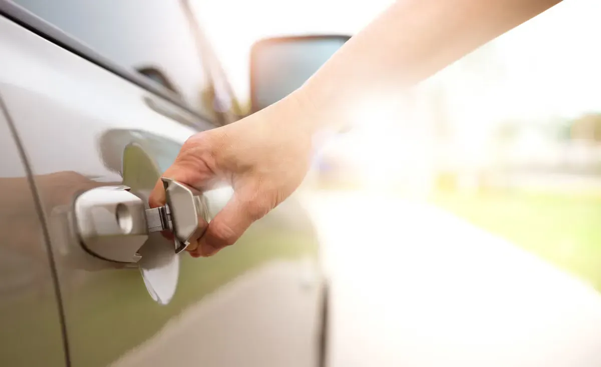 A person is opening the door of a car with a key. A person is opening the door of a car with a key.