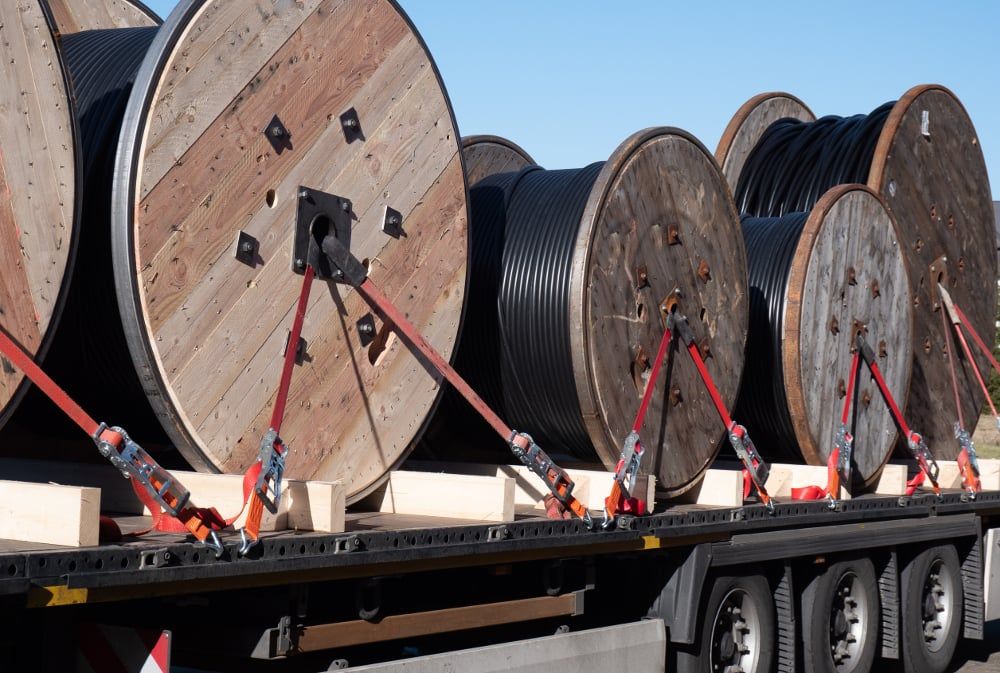 A bunch of wooden spools of wires are stacked on top of each other