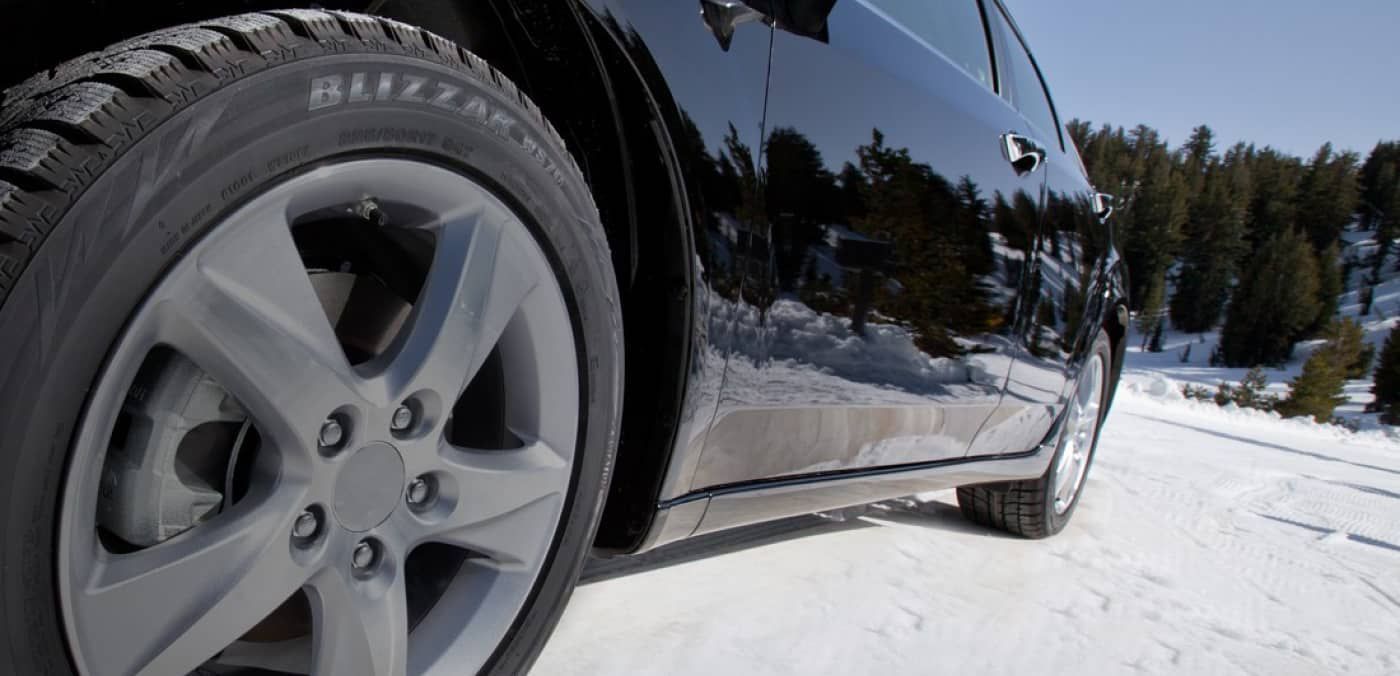 A close up of a car 's tire on a snowy road A close up of a car 's tire on a snowy road