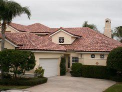A large house with a red tile roof and a white garage door.