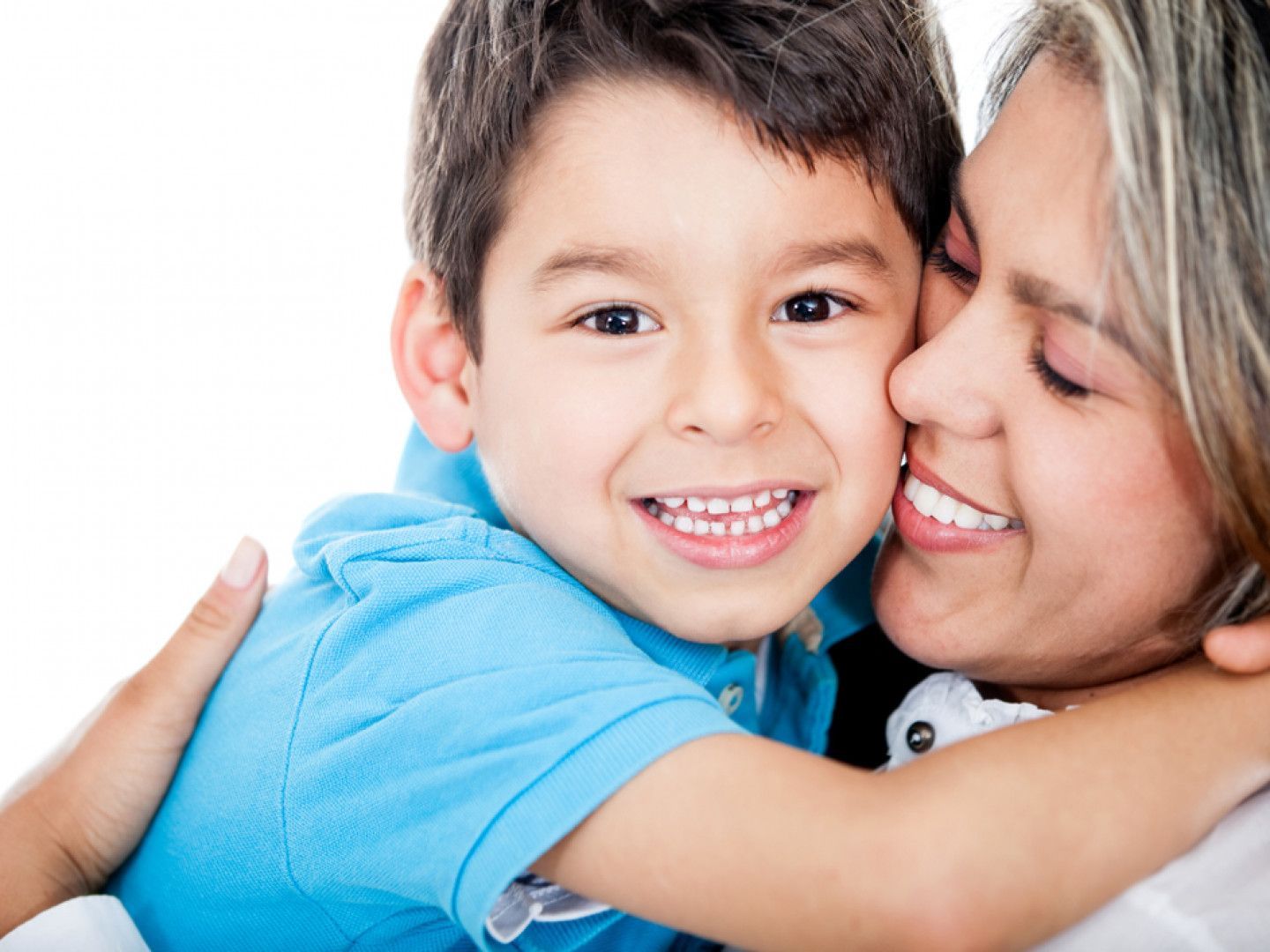 Smiling child in blue shirt hugging a smiling adult in a close-up embrace