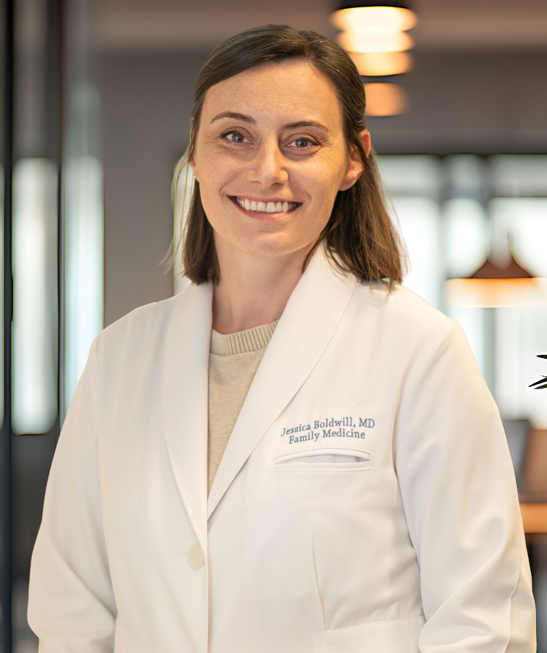 Smiling medical professional in a white coat standing indoors