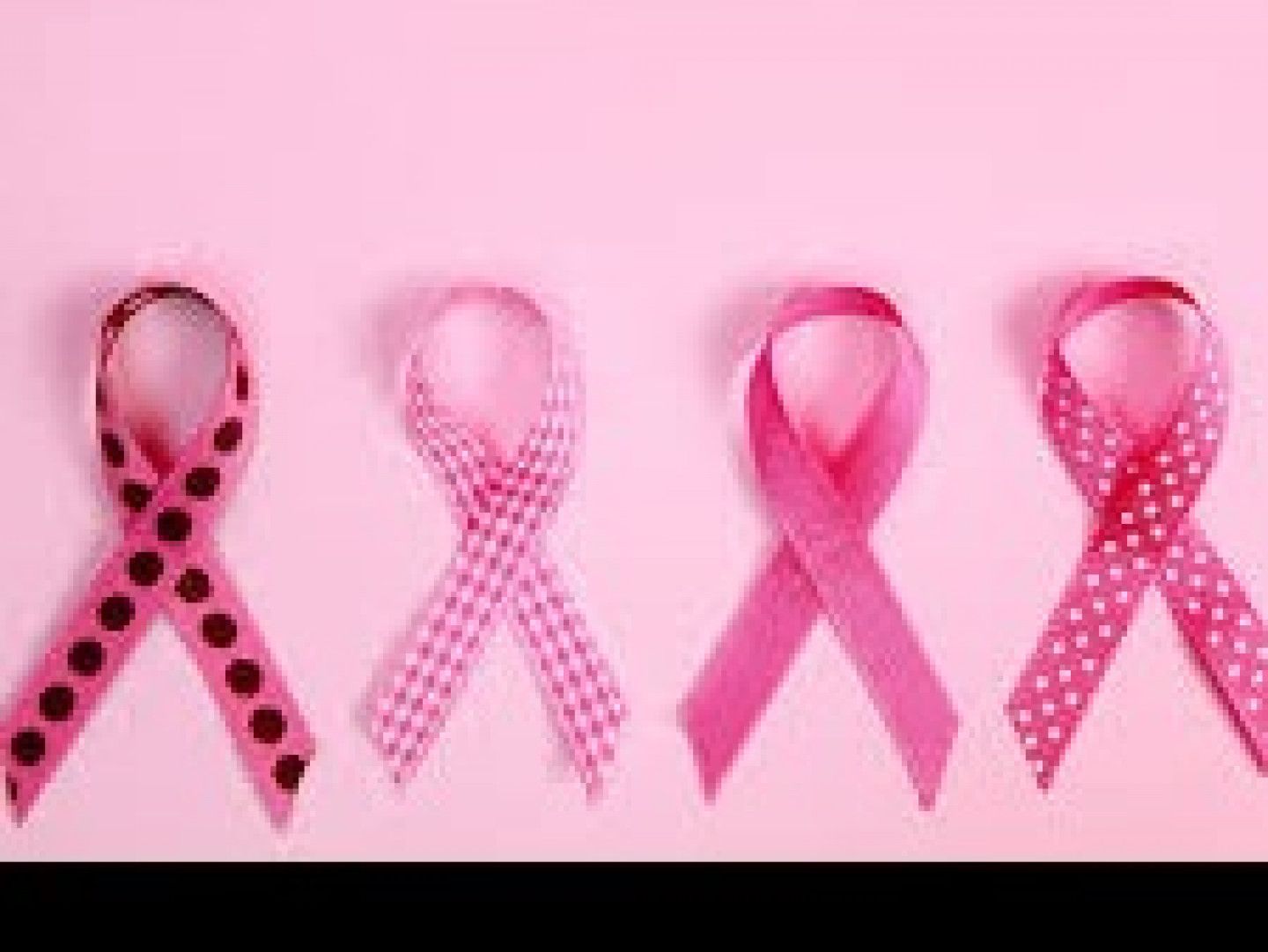 Four pink breast cancer awareness ribbons on a pink background