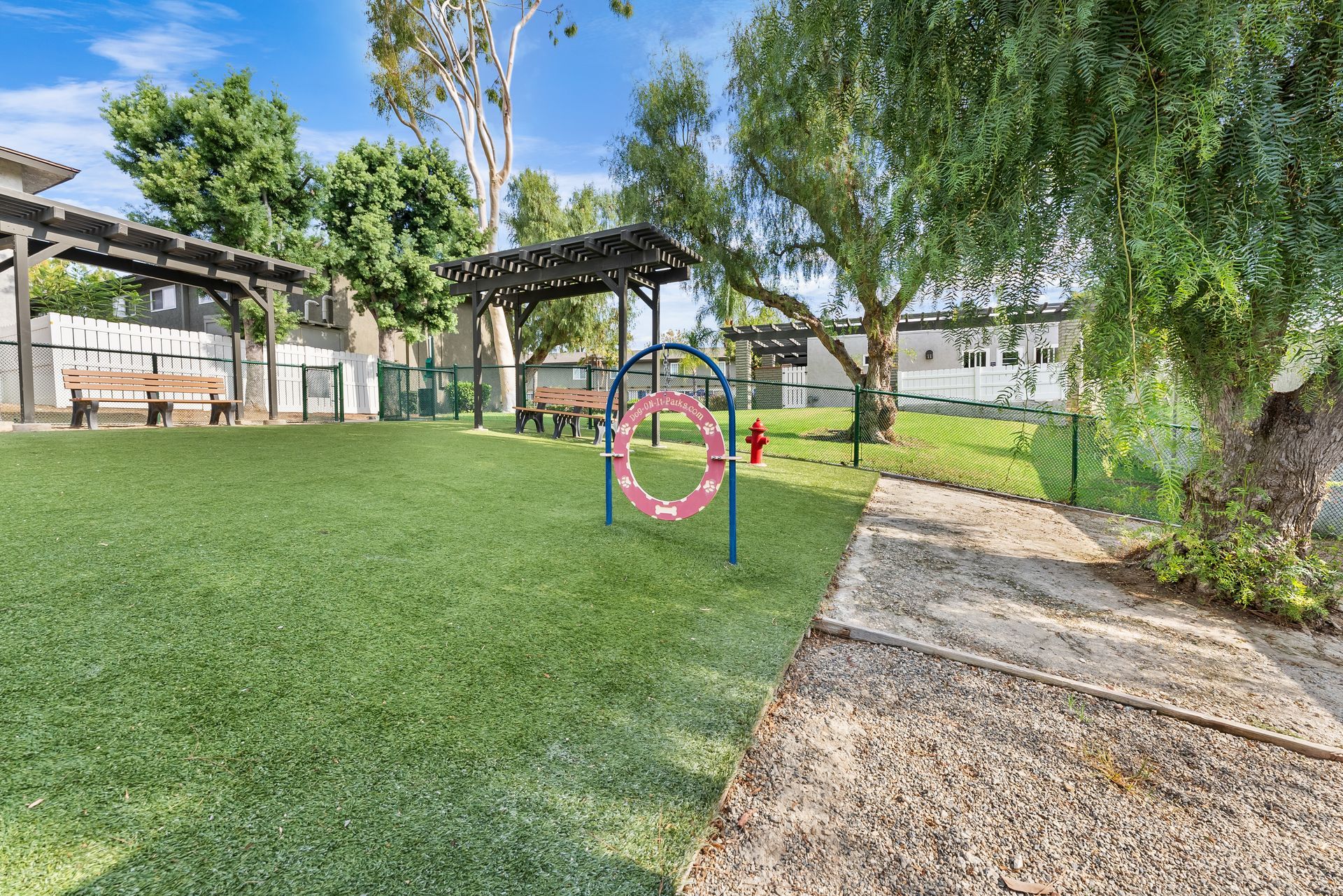 fenced in turf with benches and dog agility equipment
