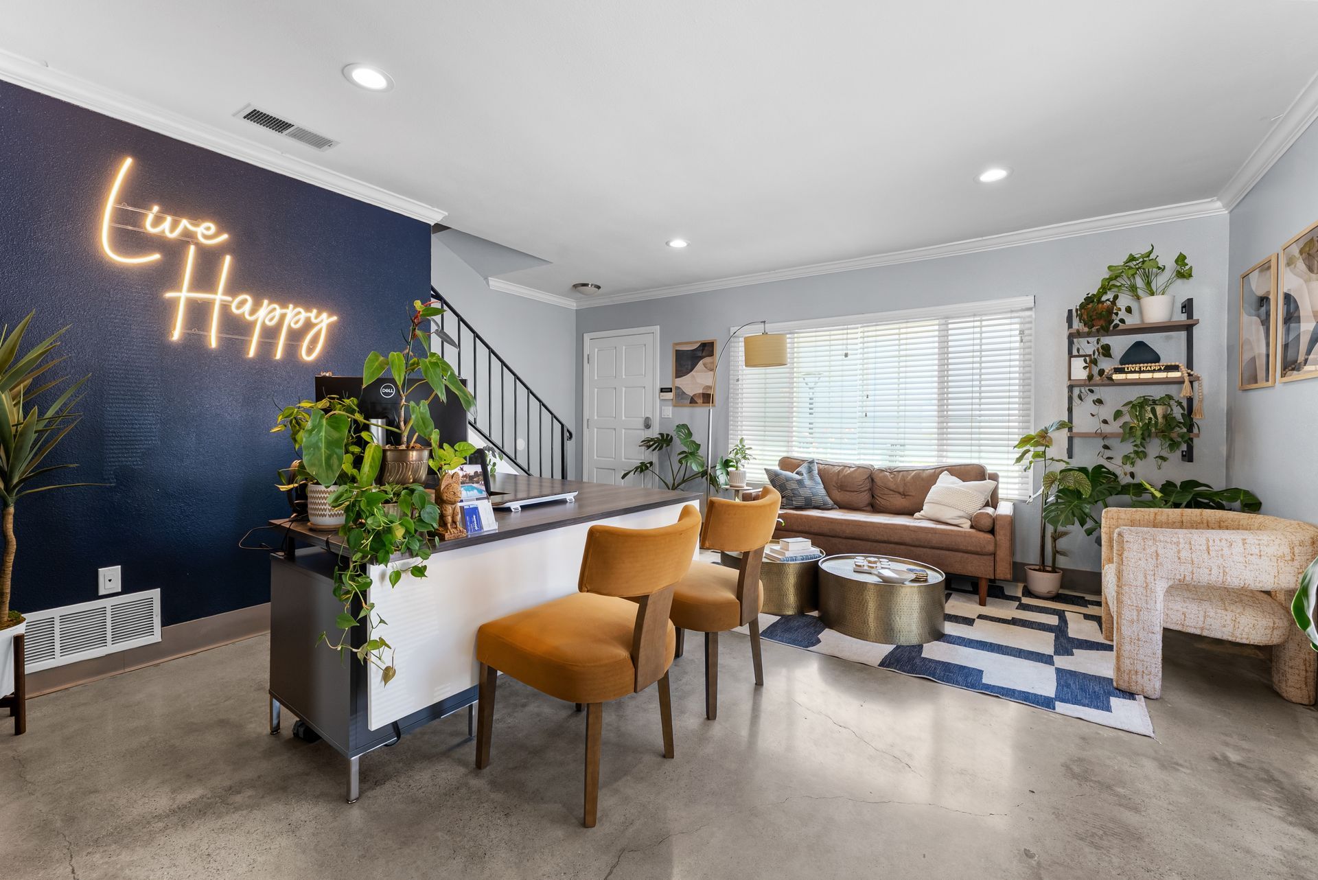 office with desk, chairs, couch, and Live Happy sign